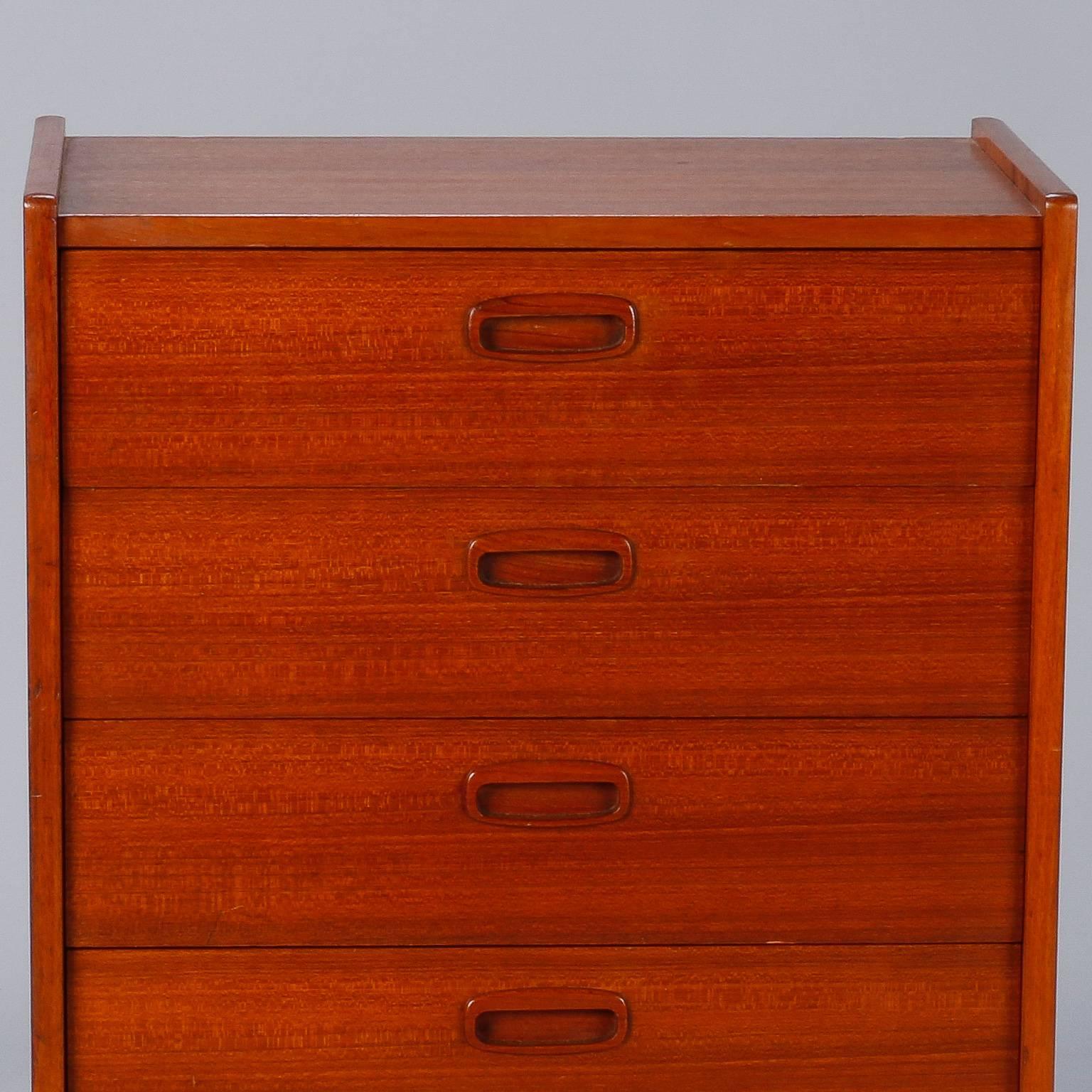 Found in Europe, this circa 1960s narrow five drawer walnut chest on base with tapered legs. Drawers have inset wood handles. Top has a faint dark spot and minor dings to rails - back edge has surface splinter. 
