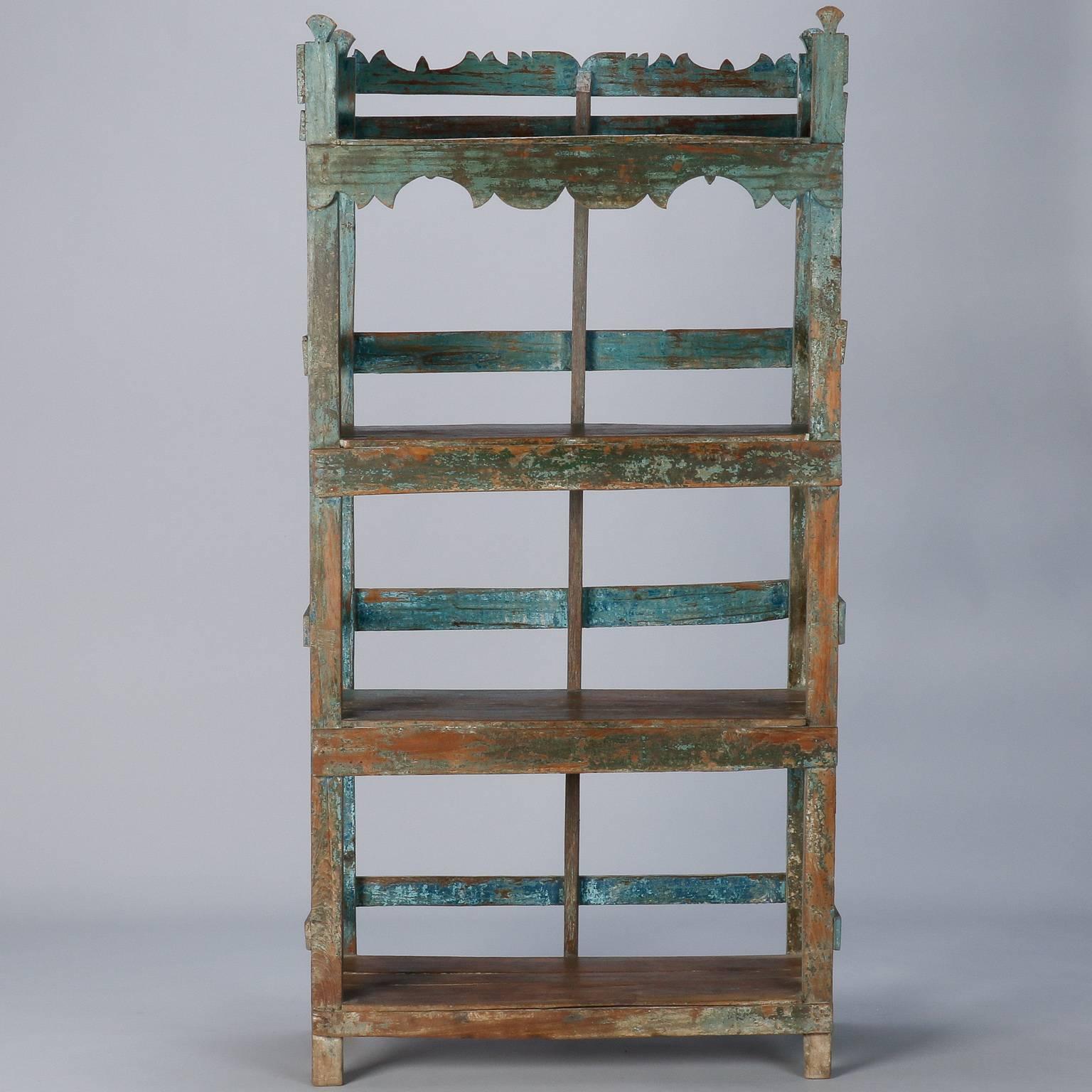 Chinese four shelf étagère with carved details on the top back and apron, circa 1900s. Original blue green paint has areas with considerable wear and loss. The piece has been sanded for a more refined, yet authentic antique painted finish.
  
