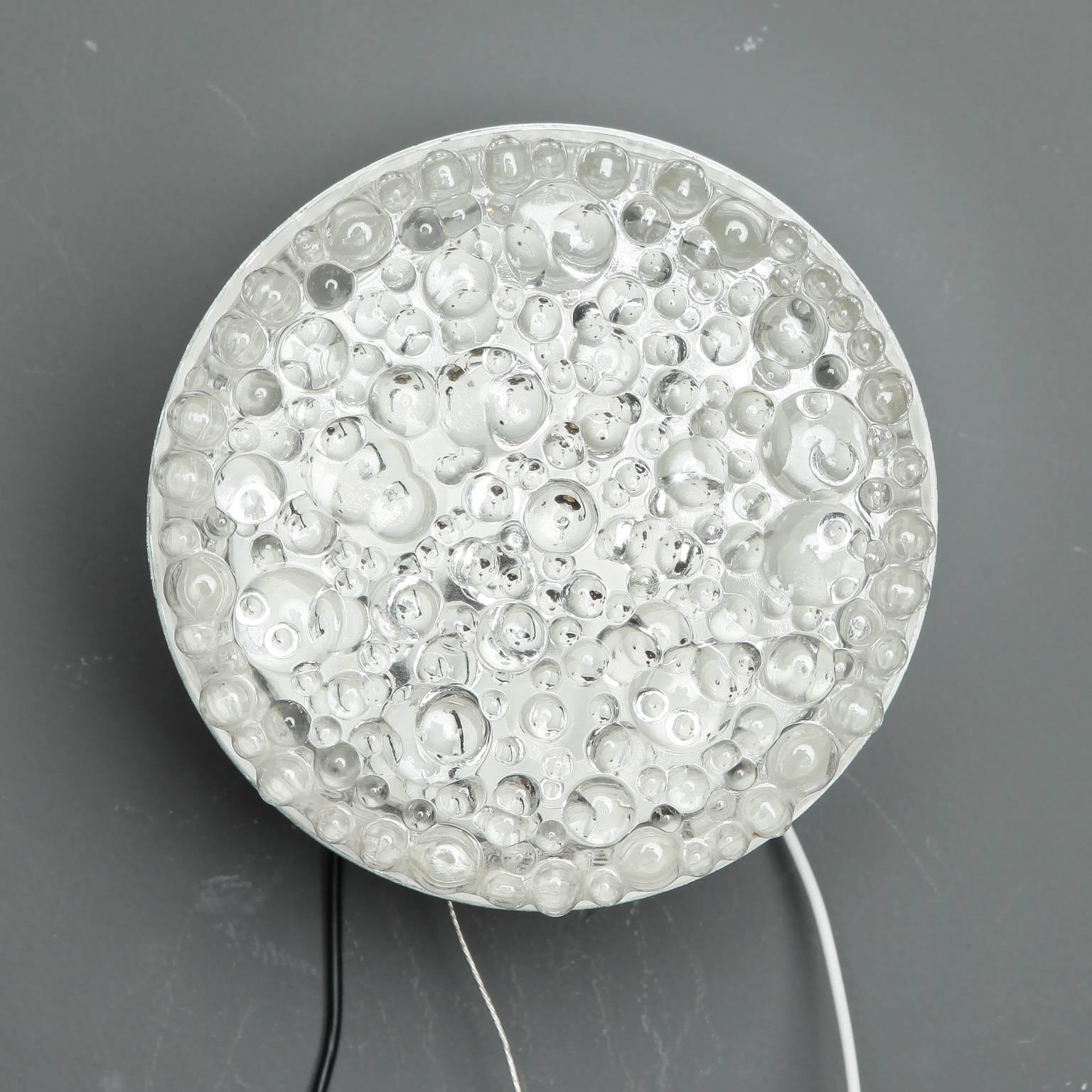European clear glass round light fixture can be used as a sconce or flush mount fixture, circa 1970s. Molded glass has a bubble texture to the surface. New wiring for US electrical standards. Currently eight lights available. Sold and priced