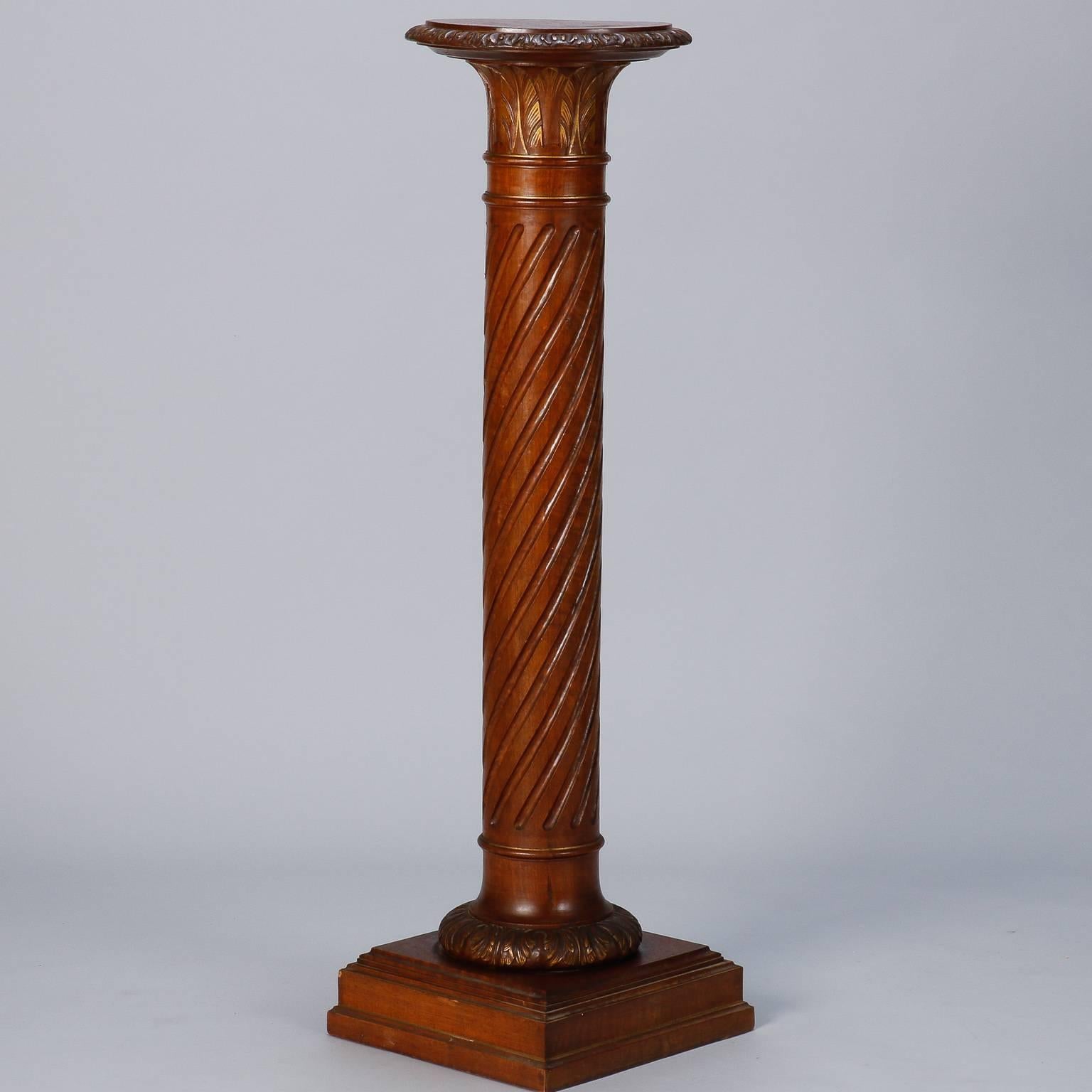 Classic column form stand made of wood with stepped pedestal base and twisted reeded surface to column. Leaf form carved details appear to support table top which also has a decorative carved edge. Great piece to display a plant, sculpture or piece