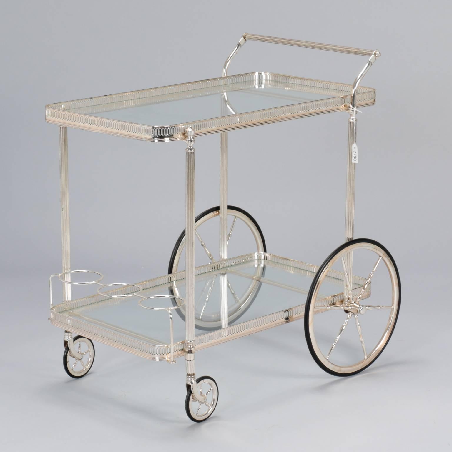 Found in France, this midcentury trolley or bar cart dates from the 1960s. Metal cart has a polished nickel finish, two glass shelves with galleries, bottle holders on the lower level, and reeded legs. 

