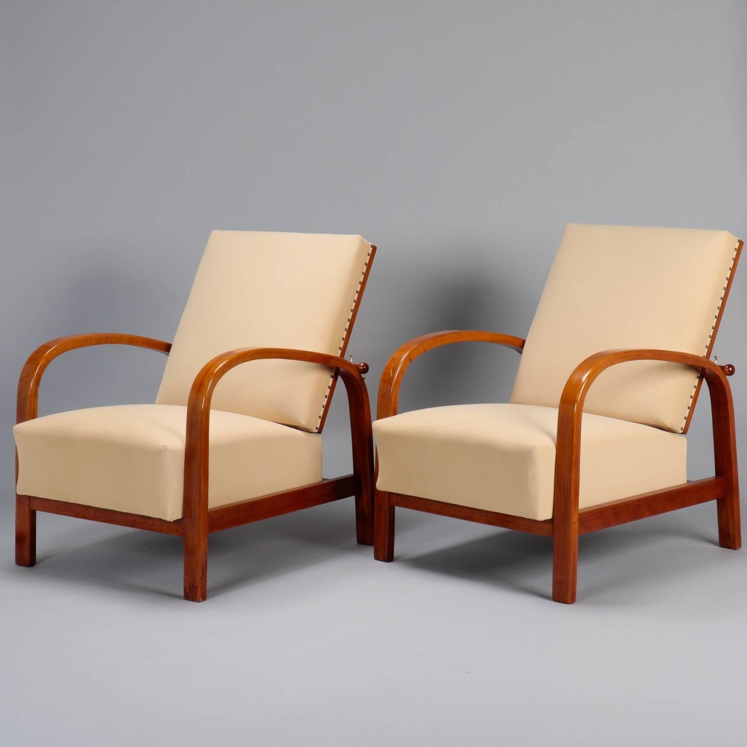 Palisander armchairs, circa 1940s found in France have dark polished wood frames with curved bentwood arms and angled seat backs. Newly upholstered in cream colored micro suede. Sold and priced as a pair.