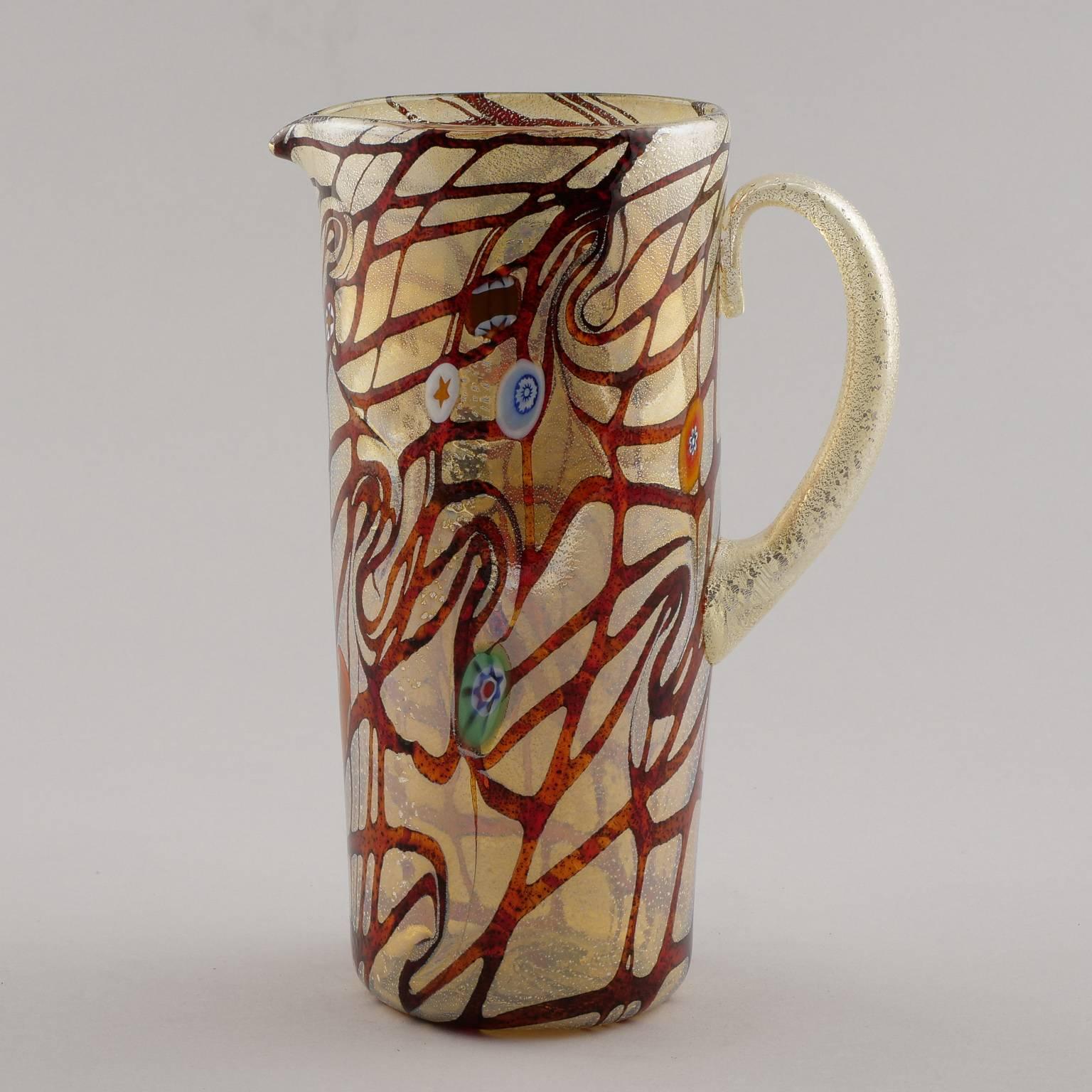 Set of contemporary Murano glass pitcher with six coordinating tumblers. Colors of set are burnt orange, red, gold with streaks of iridescent silvery white and blue and green floral accents. Measurements shown are for the pitcher. Glasses are 4.5