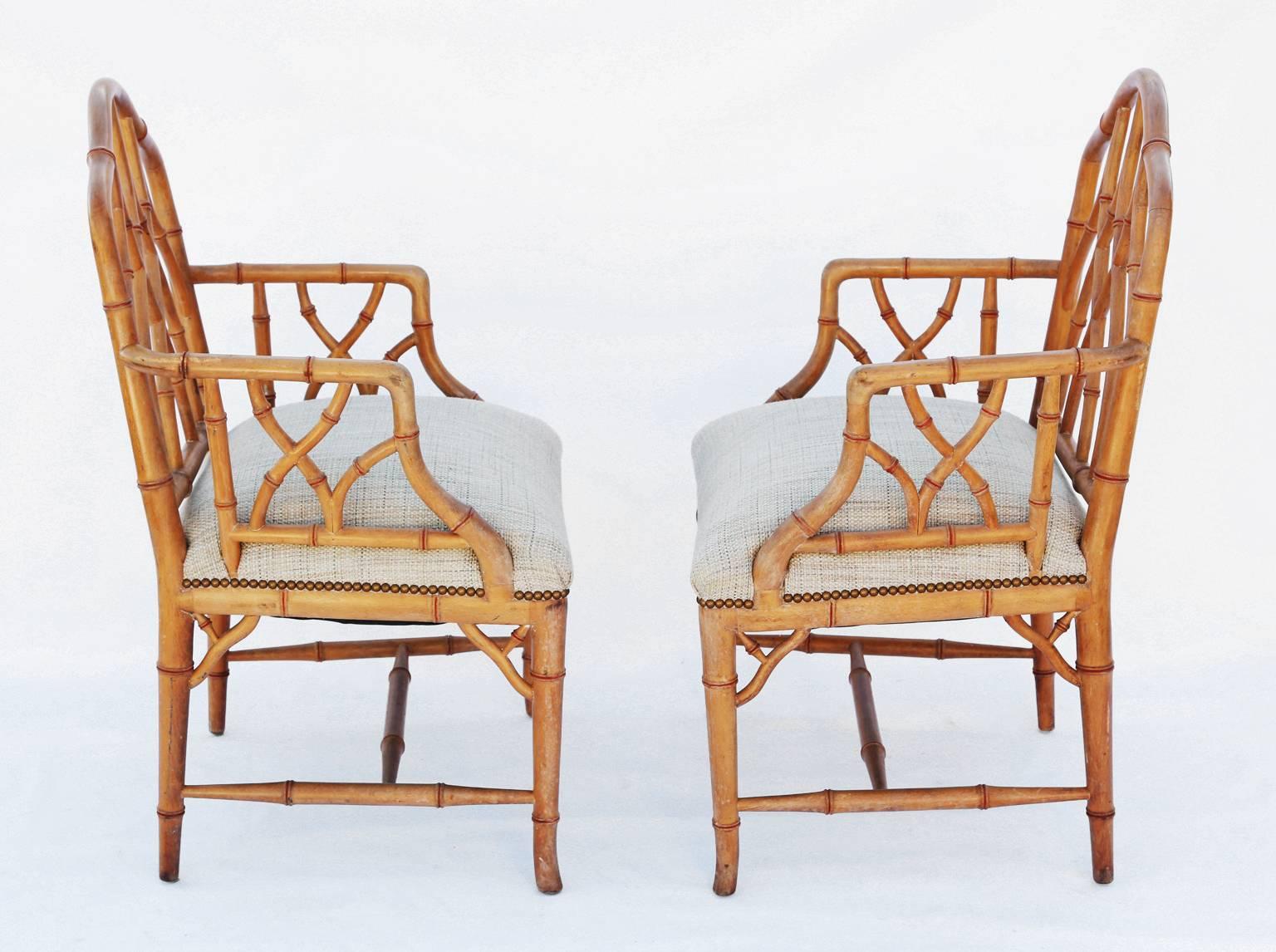 Pair of armchairs, of pine, carved as bamboo, in the Chippendale style, with a back inset with triple Gothic-arch, its crown seat upholstered with nails, flanked by outswept arms, raised on flared legs, joined by H-stretcher.

Stock ID: D3534.