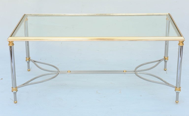 Coffee table, having a rectangular glass top, on chromed table base, accented by polished brass, its round legs joined by unusual stylized stretcher, ending in toupie feet.

Stock ID: D9450