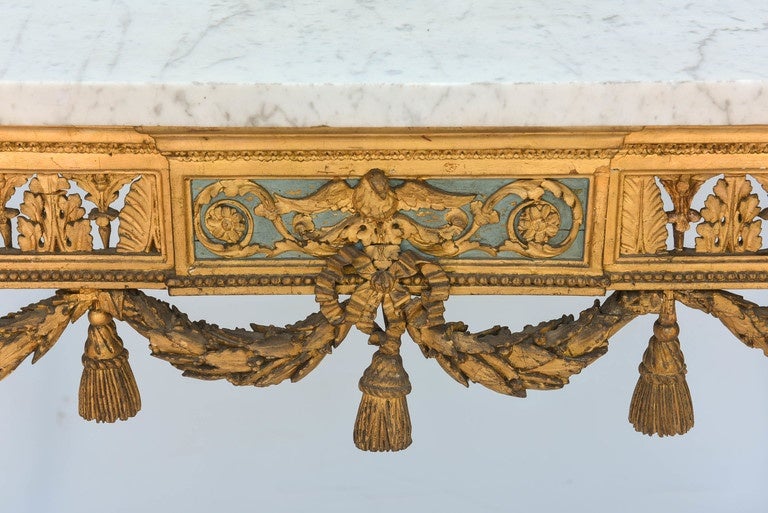 Console table, having a rectangular top of Carrara marble, on elaborately carved giltwood base, its pierced foliate apron carved with palmettes and anthemion, centered by plaque outcarved with an eagle, flanked by scrollwork, the frieze having