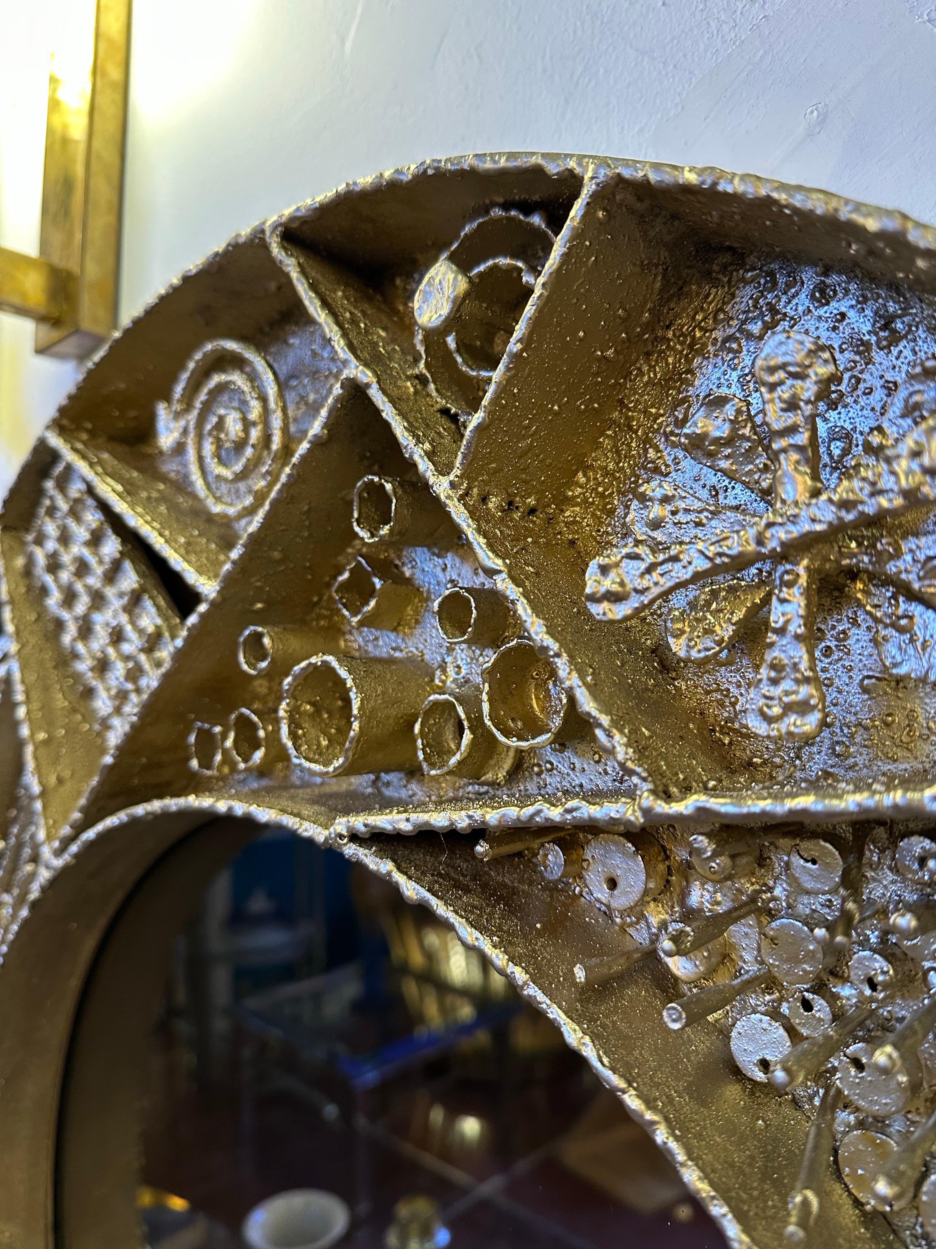 Paul Evans Style Mirror, Sculpted Metal with Gold Gilding. Large individually crafted metal over a wood base creating a magnificent wall mirror, decorated with a variety of abstract patterns in the applied relief. Beautifully handcrafted work. 