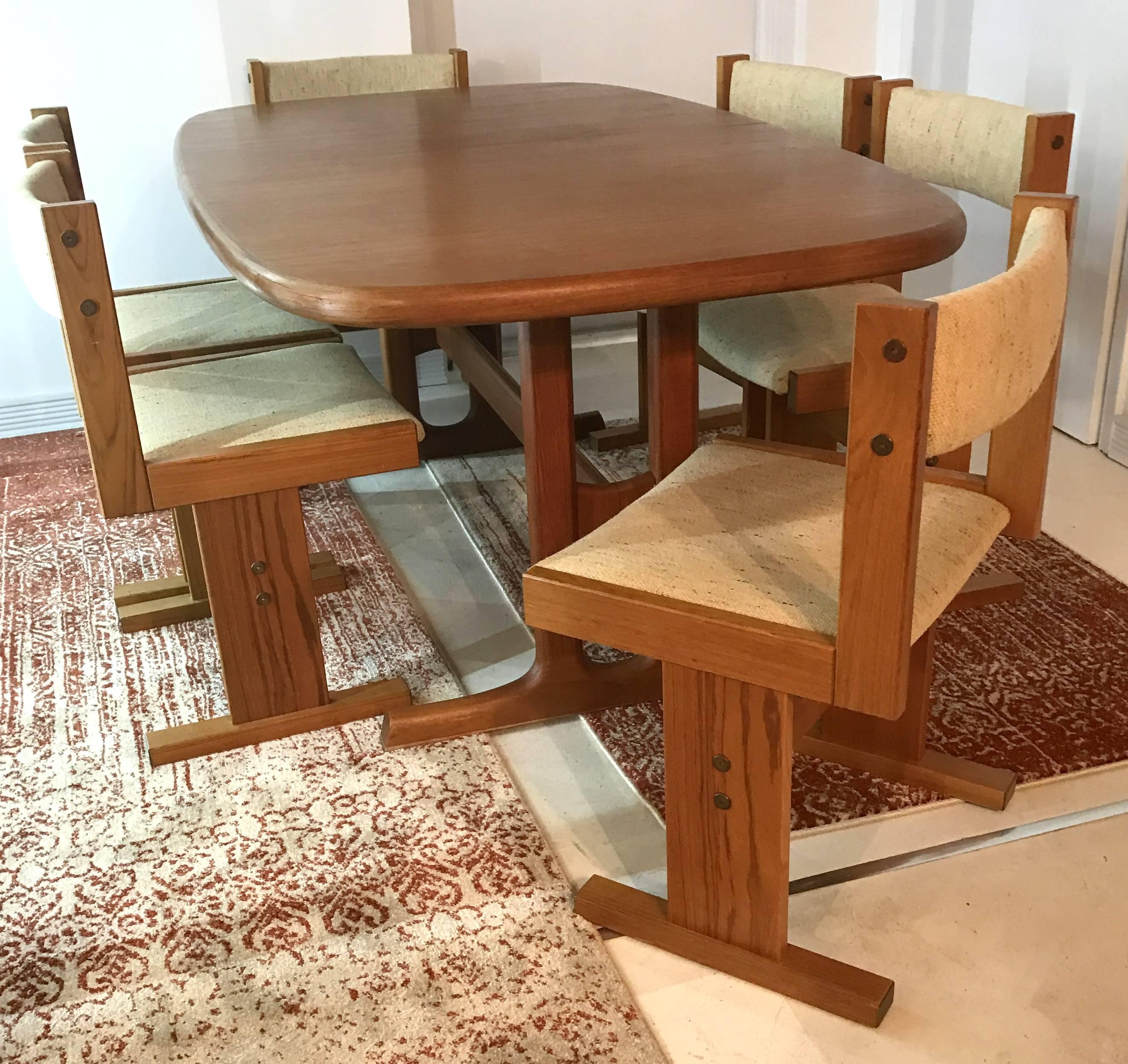 Mid-century Danish teak dining table extends by inserting the hidden leaf stored in a compartment under the table. The leaf adds 19.5