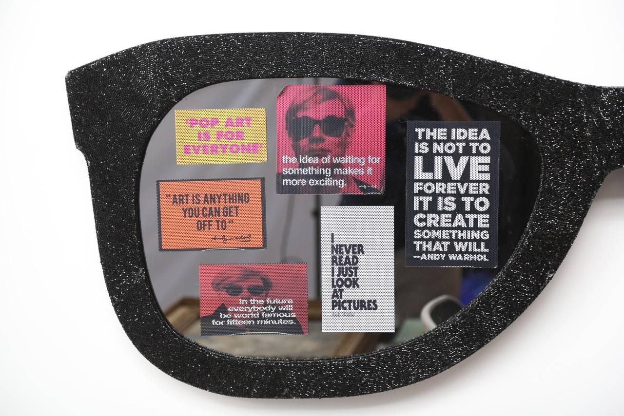 An Andy Warhol tribute exposition piece shown at Art Basel Week, Miami 2015.
A pair of giant sunglasses made of sculpted wood and covered with crushed black crystals, smoked mirrors and adhesive stickers of Andy Warhol's Famous Quotes. The stickers