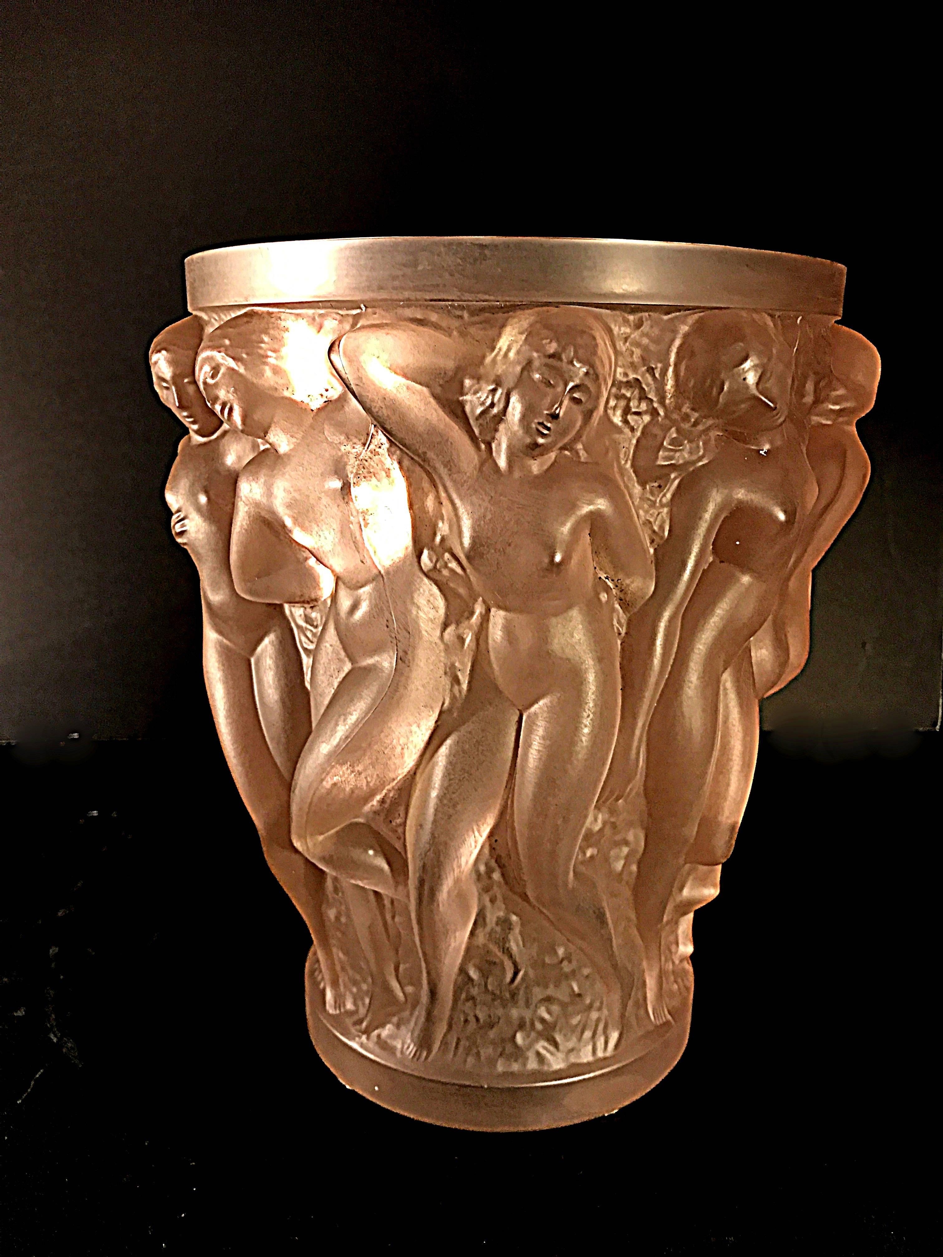 The Bacchantes vase was designed by Rene Lalique on July 22, 1927 and has been in production at Lalique glass ever since. This Bacchantes rose colored
vase is signed Lalique, France.
