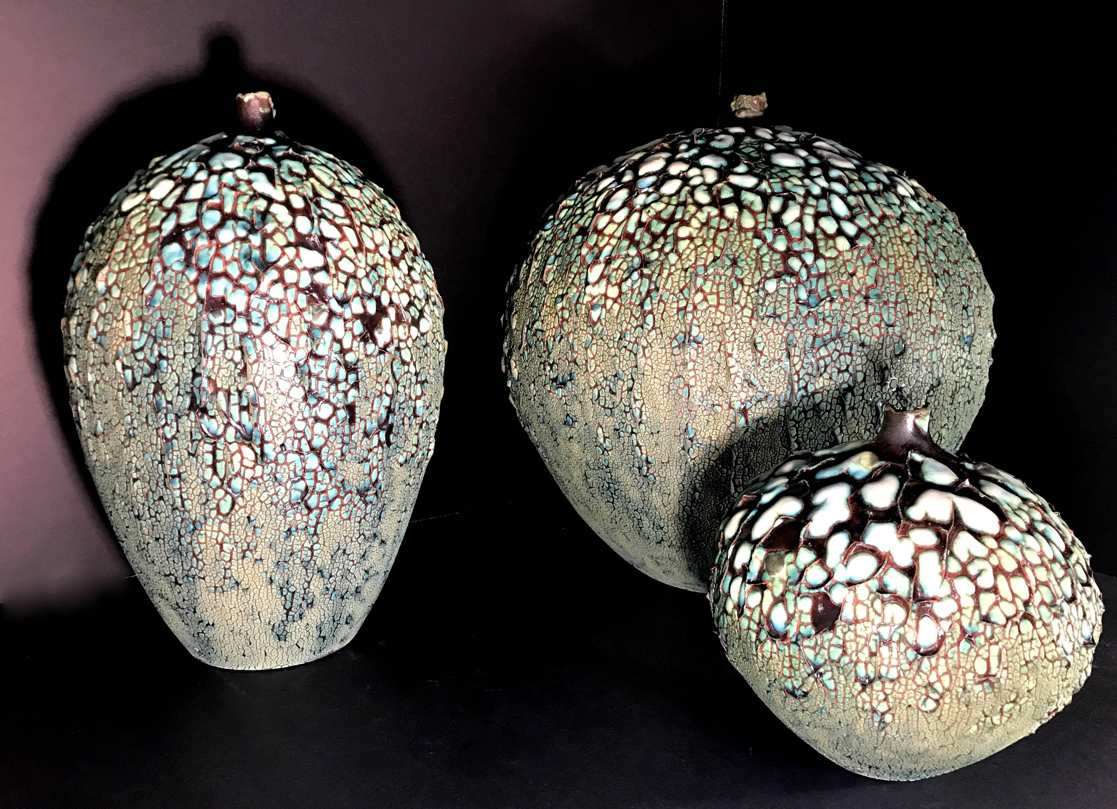 Four beautifully textured glazed vessels. The metallic glaze mimics the metal frame used for stained glass creating a Tiffany Wisteria lampshade effect. Each vase can be purchased individually upon request or altogether at the listed
