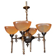 Lustre en bronze de style « mid-century » à quatre lumières, avec des abat-jours en verre prismatique Holophane