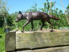 Grande sculpture de jardin en bronze représentant un renard en pleine course, réalisée selon la technique de la cire perdue
