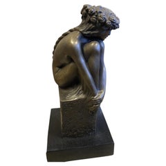 Figurine féminine assise en bronze, ornée d'une guirlande, sur un socle en marbre
