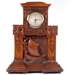 Horloge de cheminée ancienne en chêne sculpté de style Arts & Crafts, ornée d'un motif représentant un bateau-dragon