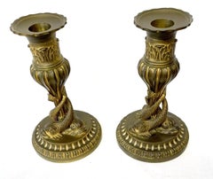 Par de candelabros antiguos de bronce dorado con motivos de delfines míticos