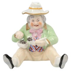 Figurita antigua de porcelana de Staffordshire de la época victoriana con forma de tabaquera