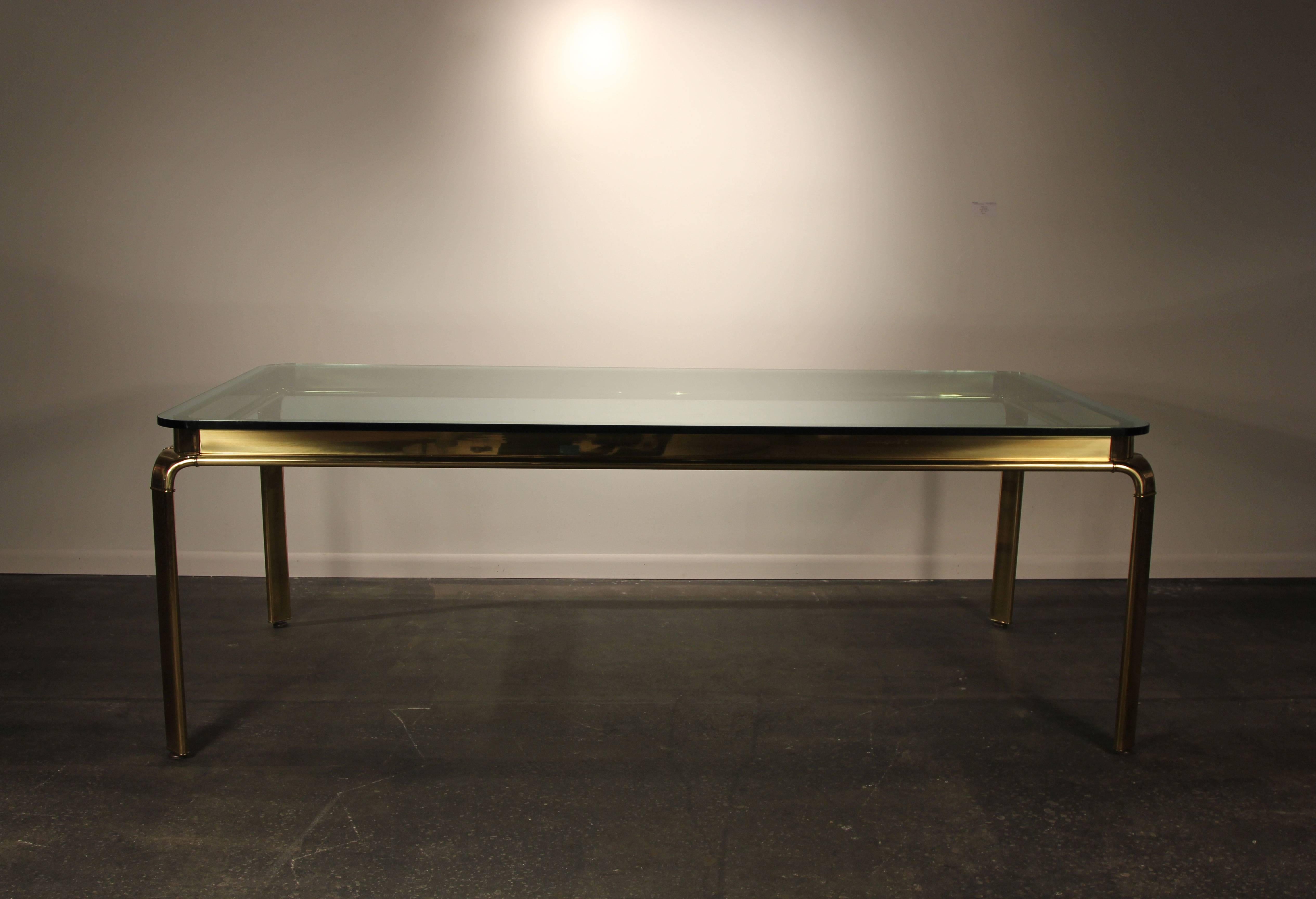 Incredible brass table by Widdicomb. With 1inch thick glass top. Radius corners. In the manner of Mastercraft, rare and unique beautiful dining table.