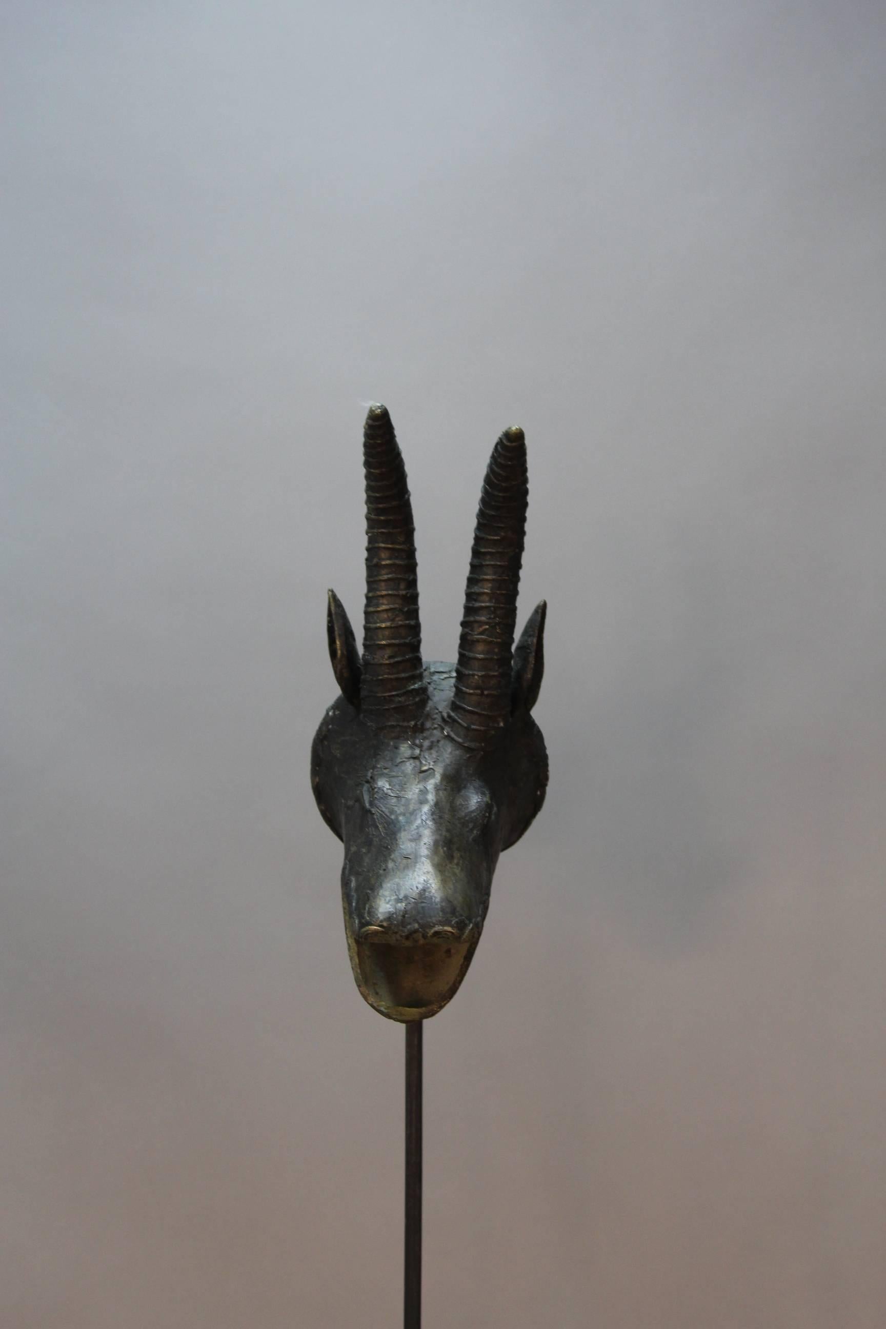 African Benin bronze antelope heads on wrought iron stands with circular base and looped poles made in France. These unusual decorative sculptures can we wired as floor lamps, holes are present in bronze fittings.
