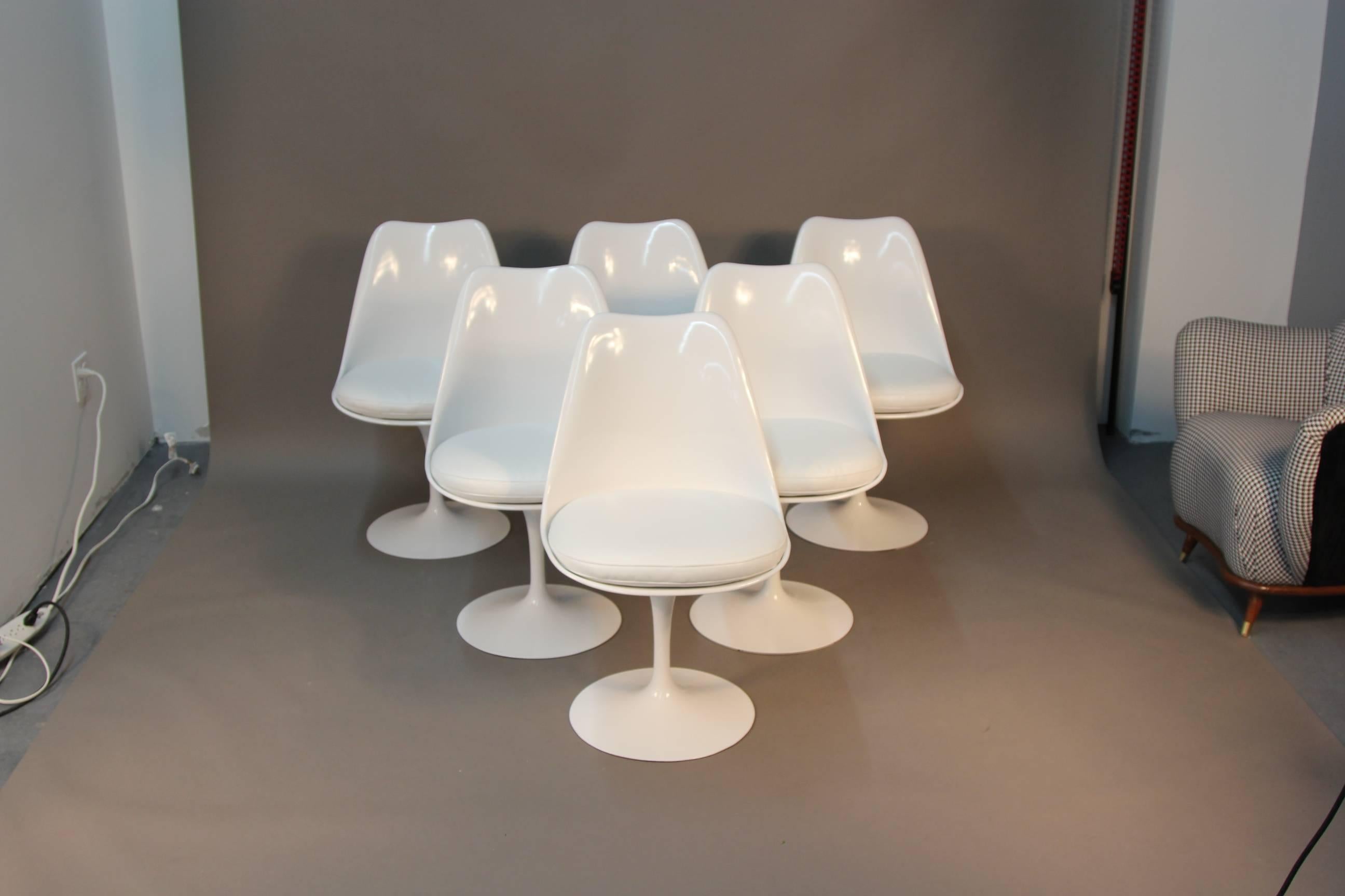 Incredible newly painted and newly upholstered set of six Saarinen tulip dining chairs. White paint, with white textured vinyl, these iconic chairs will draw attention to any dining room.
