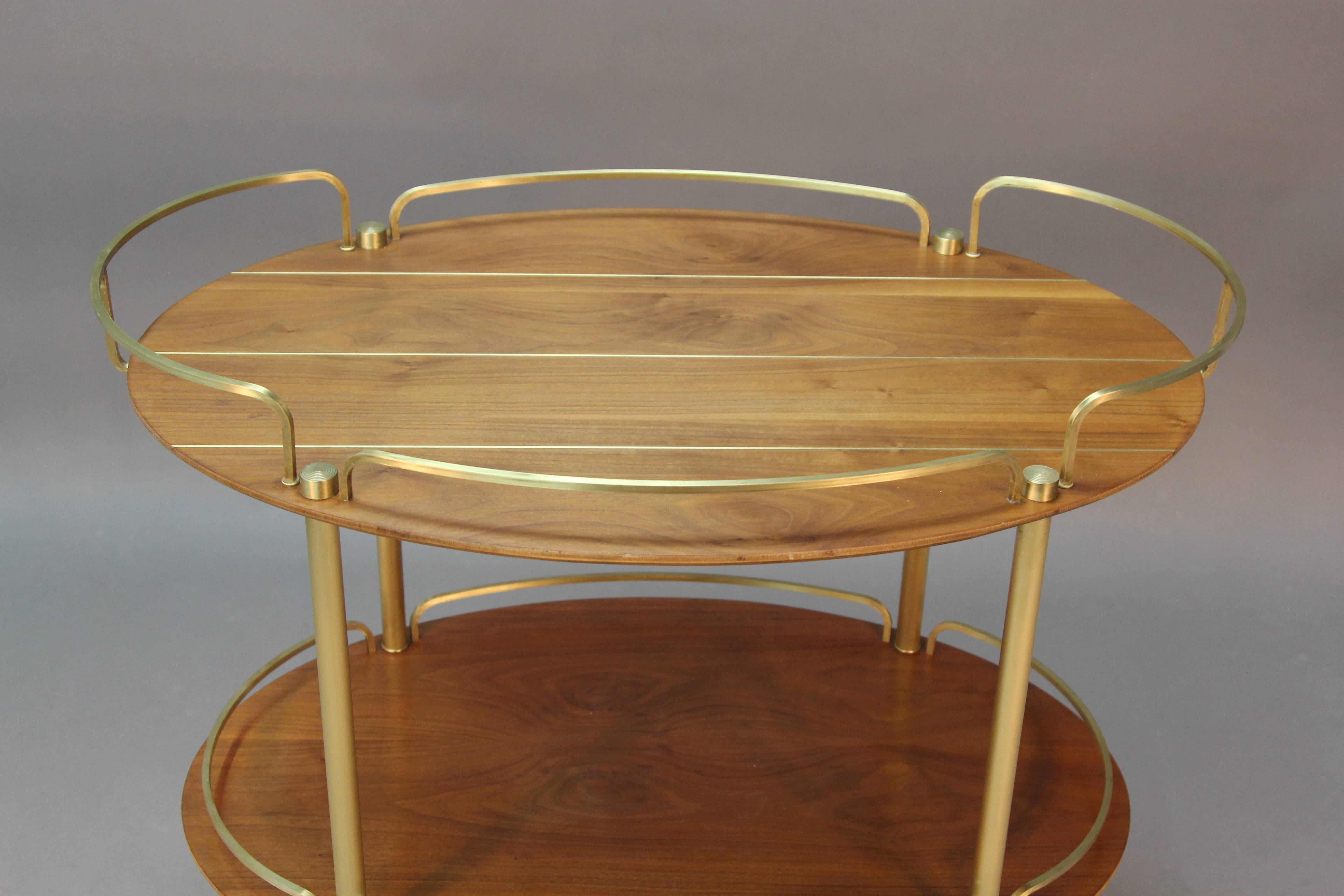 Don Draper dreams of this Mid-Century Modern teak and brass bar cart. Super chic brass detail. A great surfboard look made for martinis and Manhattans.