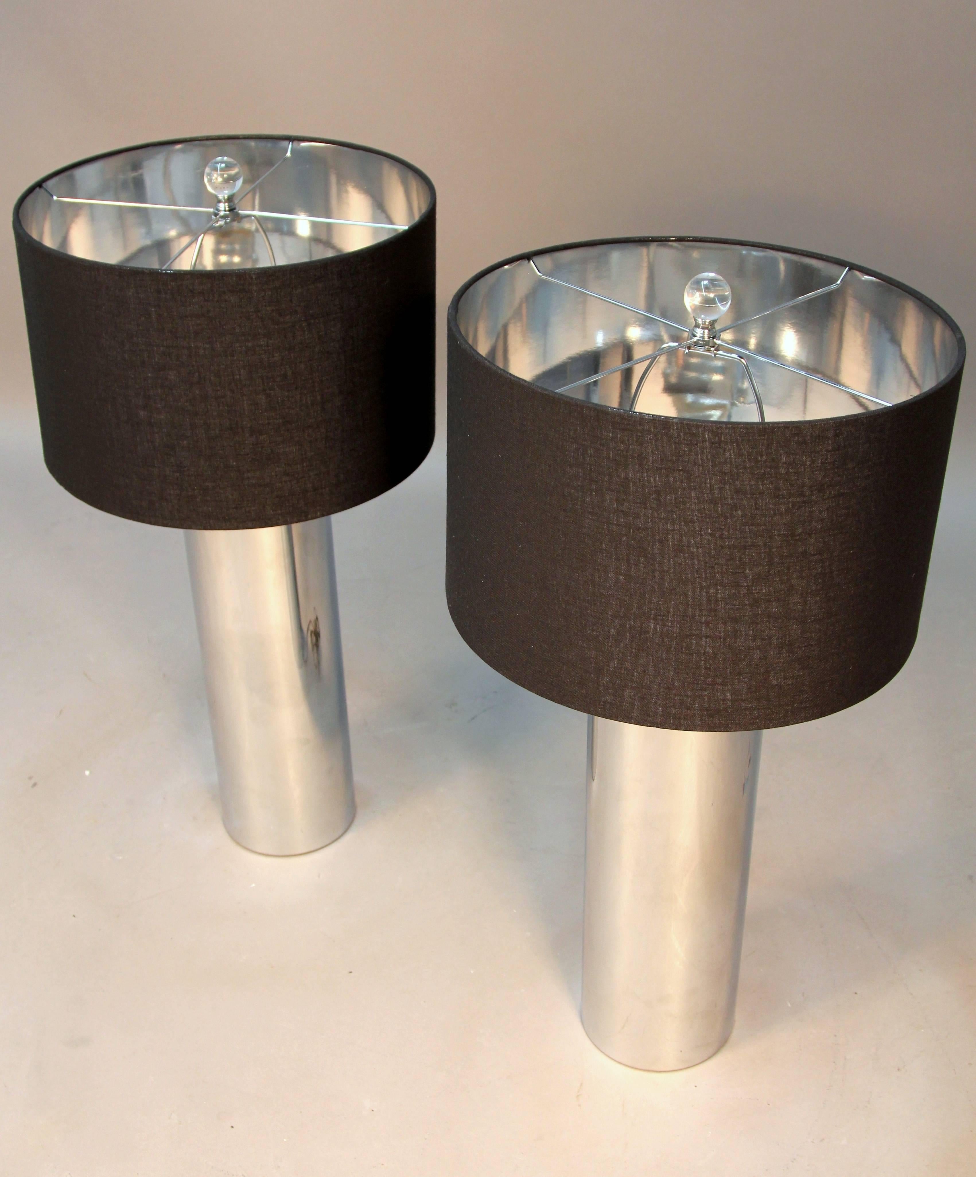 Beautiful pair of chrome tubular lamps with black shades and Lucite finial. Slick clean modern pair of Mid-Century lamps with new shades.