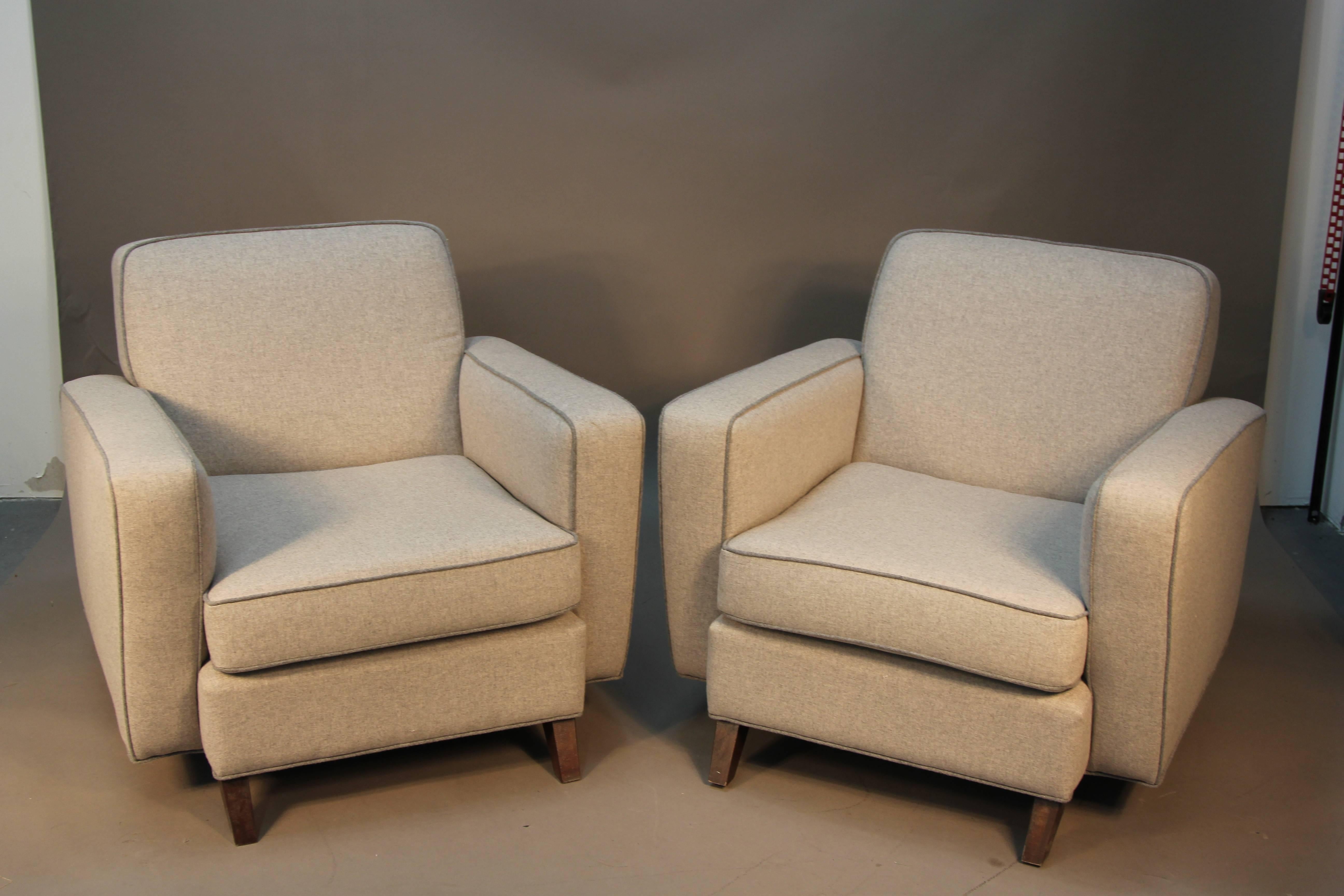 Beautifully re-upholstered in grey wool with dark grey piping, this set of Mid-Century Modern club chairs have an Art Deco feel with the high angular arms. Very comfortable to sit in, nice wood detail feet.