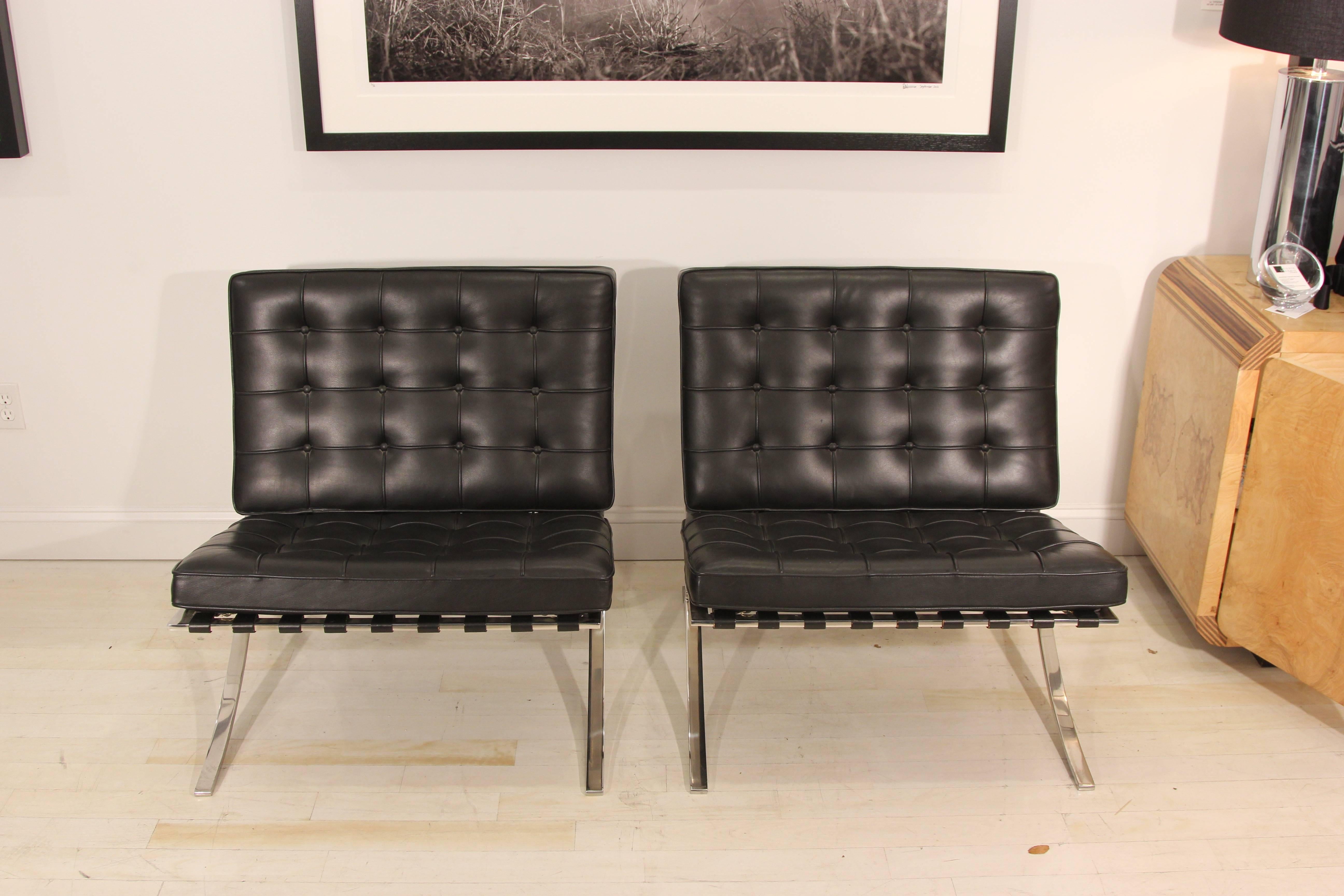 Incredible pair of Mies van der Rohe Barcelona chairs in black leather. It doesn't get much more iconic than these. In phenomenal condition, beautiful black leather. Heavy chrome frames in excellent condition. Straps in excellent condition.