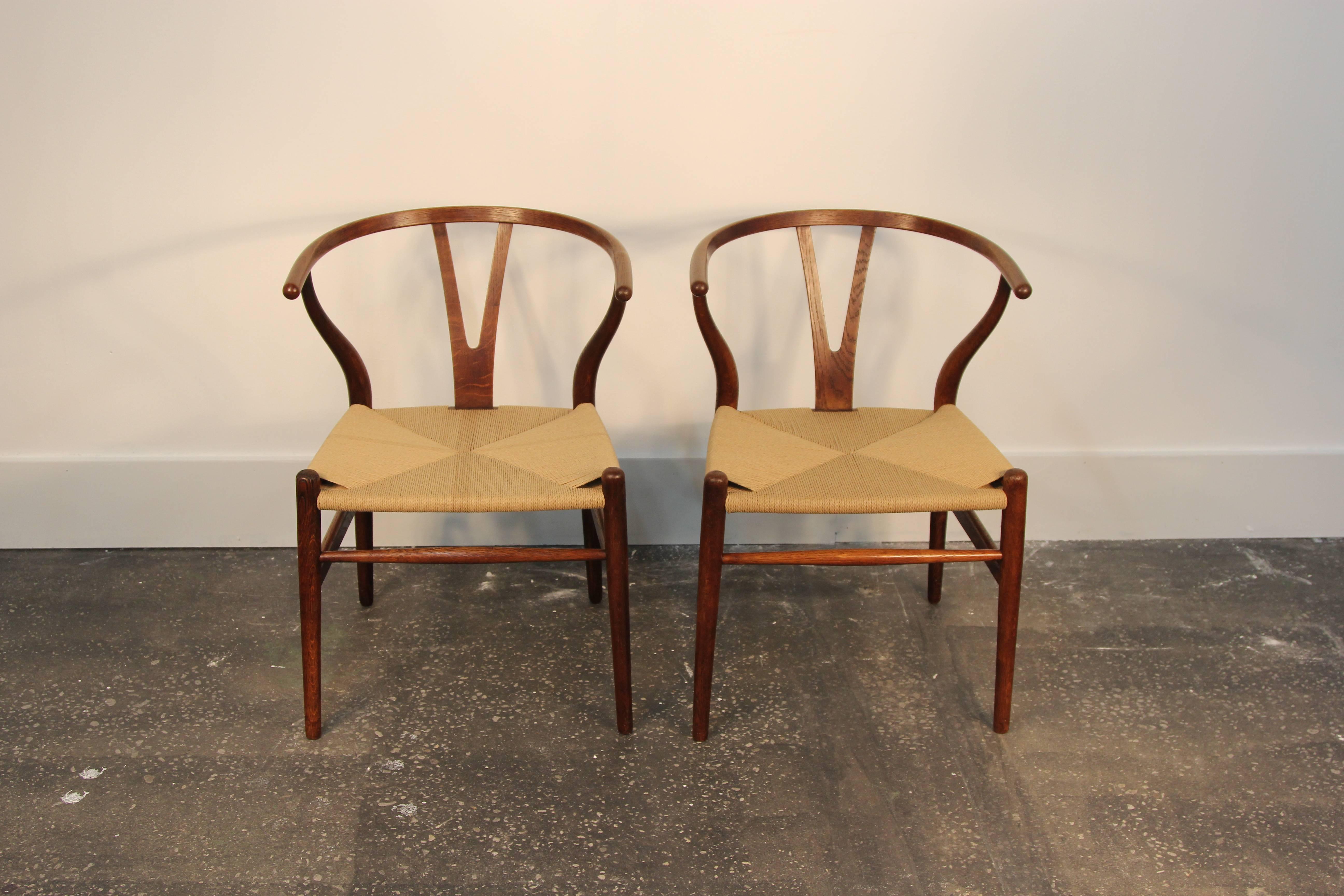 Beautifully restored pair of original Hans Wegner Wishbone chairs. Brand new Danish Chord roping to the seats. All joints have been regaled, and stain retouched. Old repair on the arm still shows at close look, but has been sanded and stained to