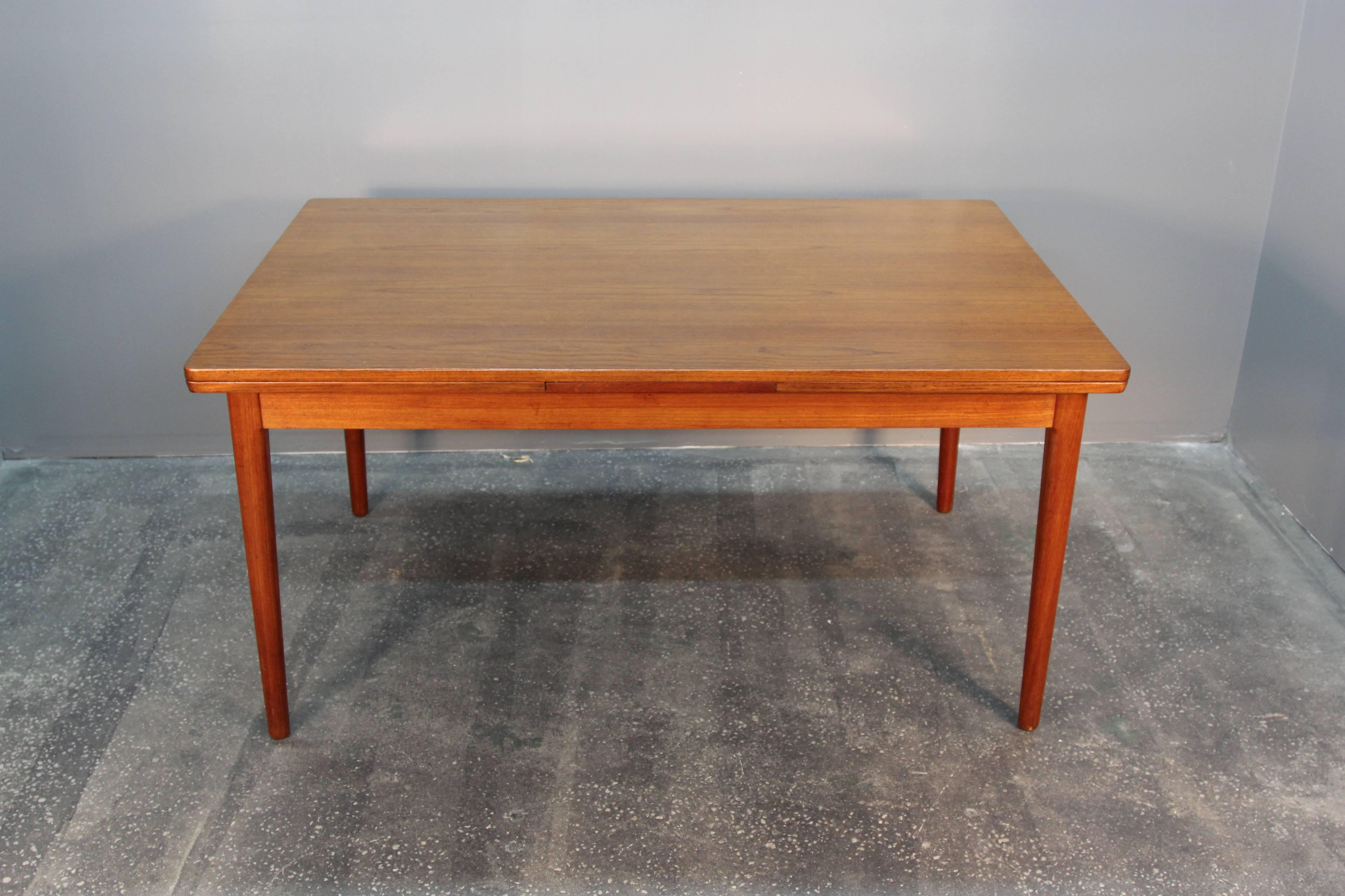 Incredible model 12 teak dining table by Niels O. Møller. Excellent condition. Two hidden extensions easily pull-out to create full length 10-12 person dining table. Beautiful wood grain and rich color.