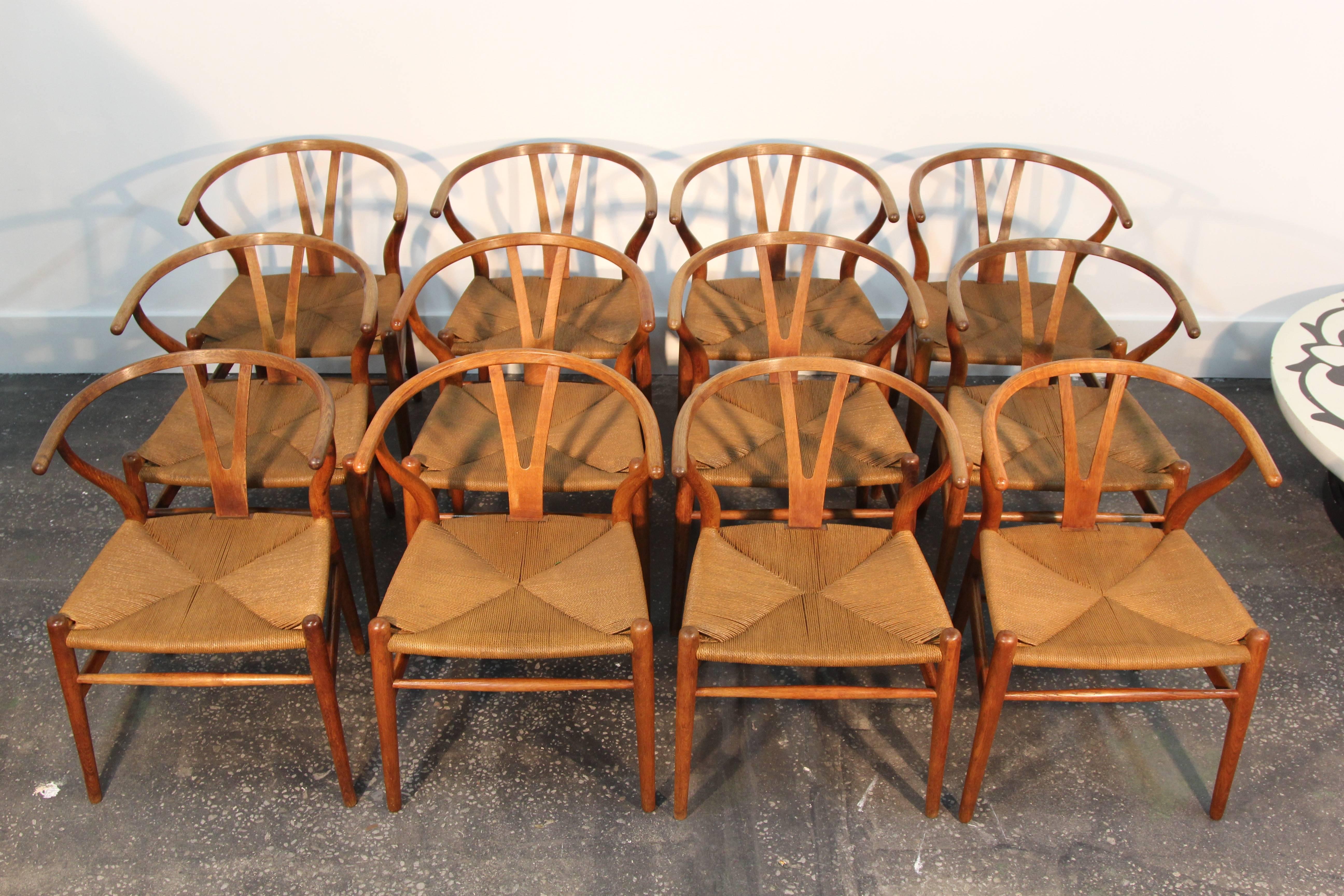 Very rarely will you find a matched set of 12 early original Hans Wegner Wishbone chairs. This set is incredible. They have been completely restored, all joints glued, wood polished and waxed. Seats stained to match perfectly and protect for future