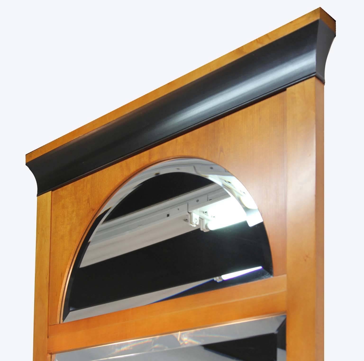 A versatile solid maple mirror with ebonized details and two beveled glass panels.