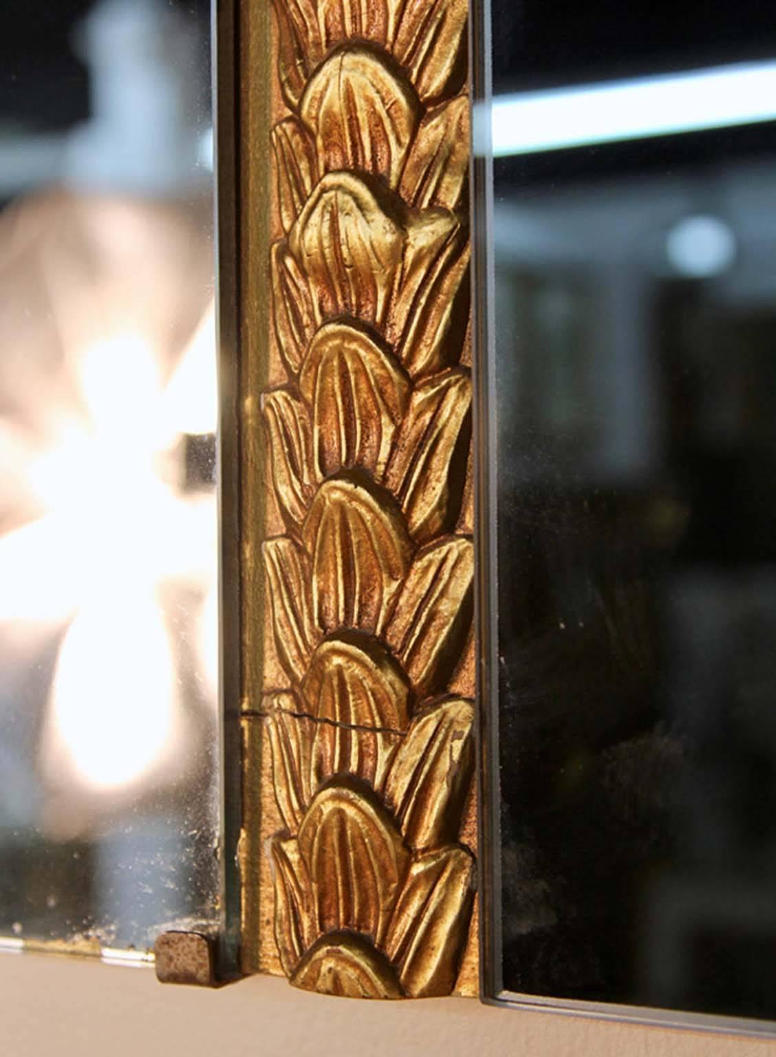 An unusual three-section wall mirror with laurel leaf banding in original gilt finish separating the clear and smoked mirror panels.