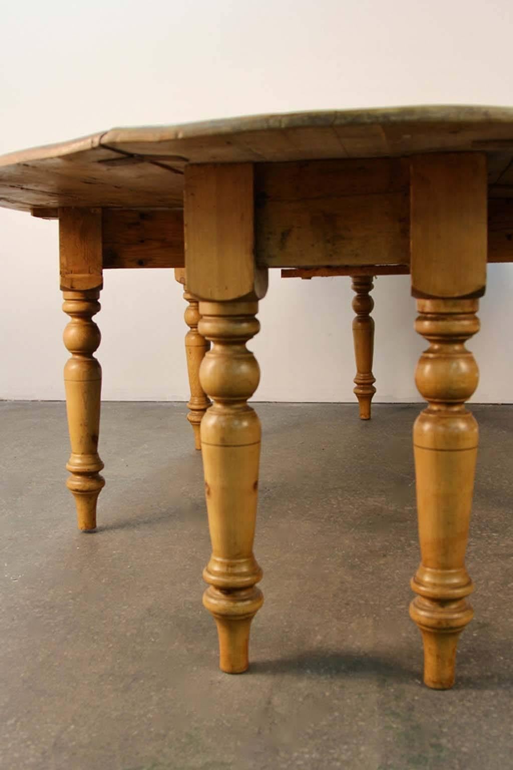 Reclaimed pine banquet size dining table with drop leaf sides. Large oval shape.