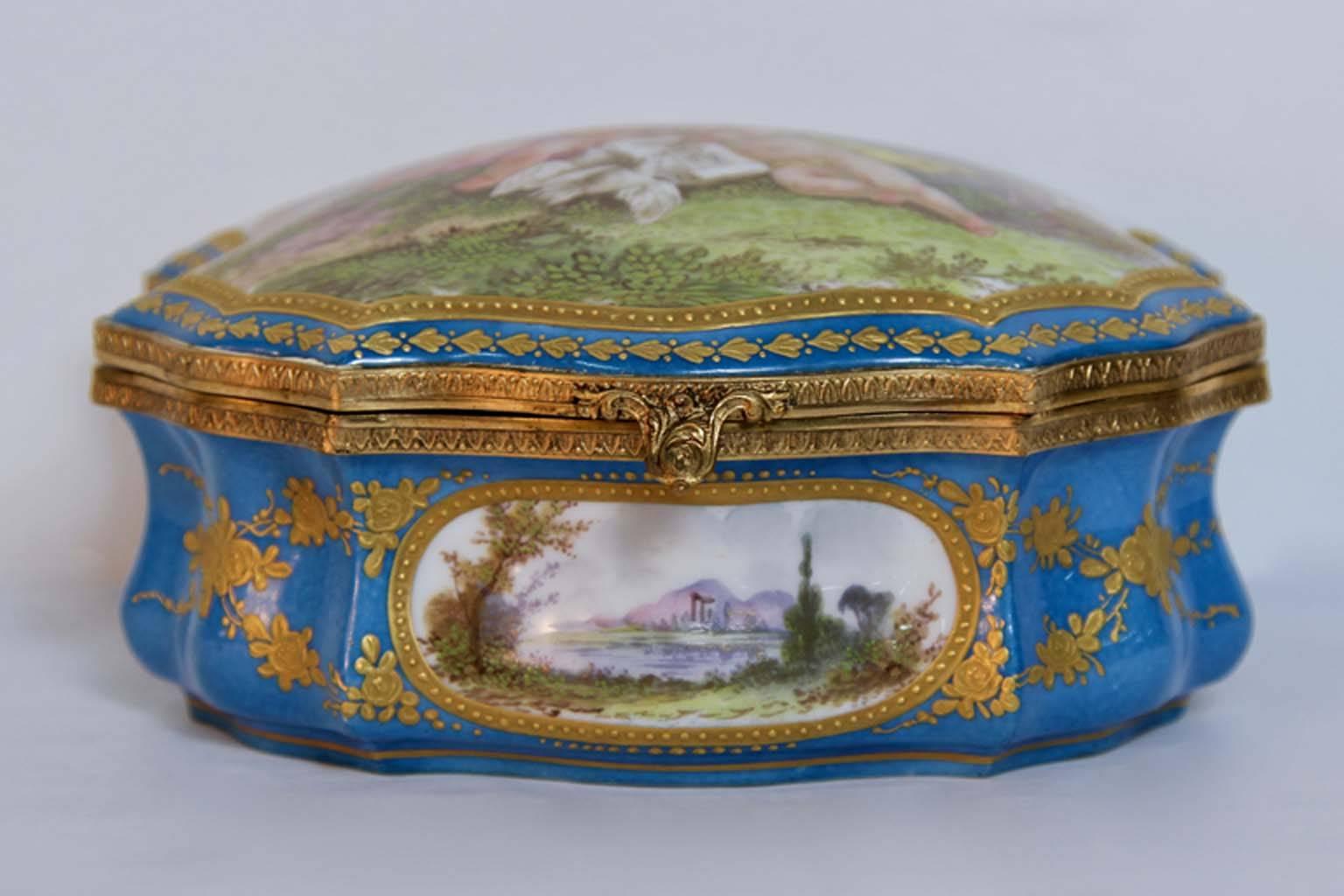 A very rare Sèvres Porcelain jewel box Bonbonniere, circa 1800. Having hand-painted seen of French country sides as well as nude putti playing in the pastures. Rich raised gold applications in the Classic serves celeste blue color. Sèvres mark