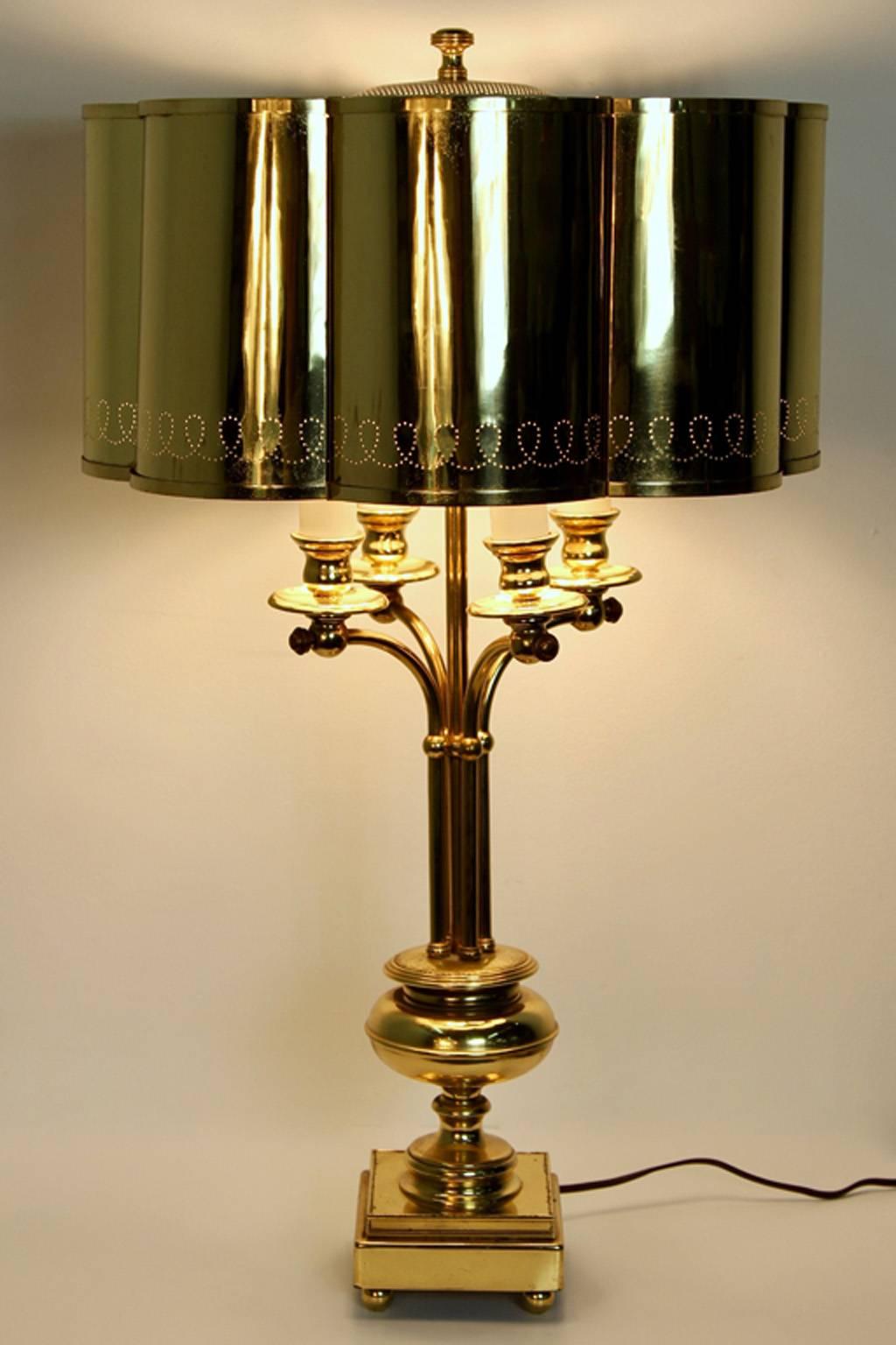 Wonderful Regency modern era table lamp in solid brass. Featuring a lobed shade, perforated decoration, and four sockets. In the manner of Finnish designer Paavo Tynell.