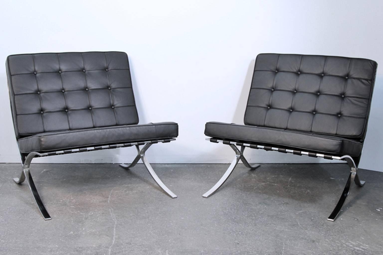 Pair of black leather Barcelona chairs in the manner of Mies Van Der Rohe. These are heavy chrome frame Barcelona chairs, but not know whether they were produced by knoll. No markings or tags. They are a high quality pair of chairs in excellent