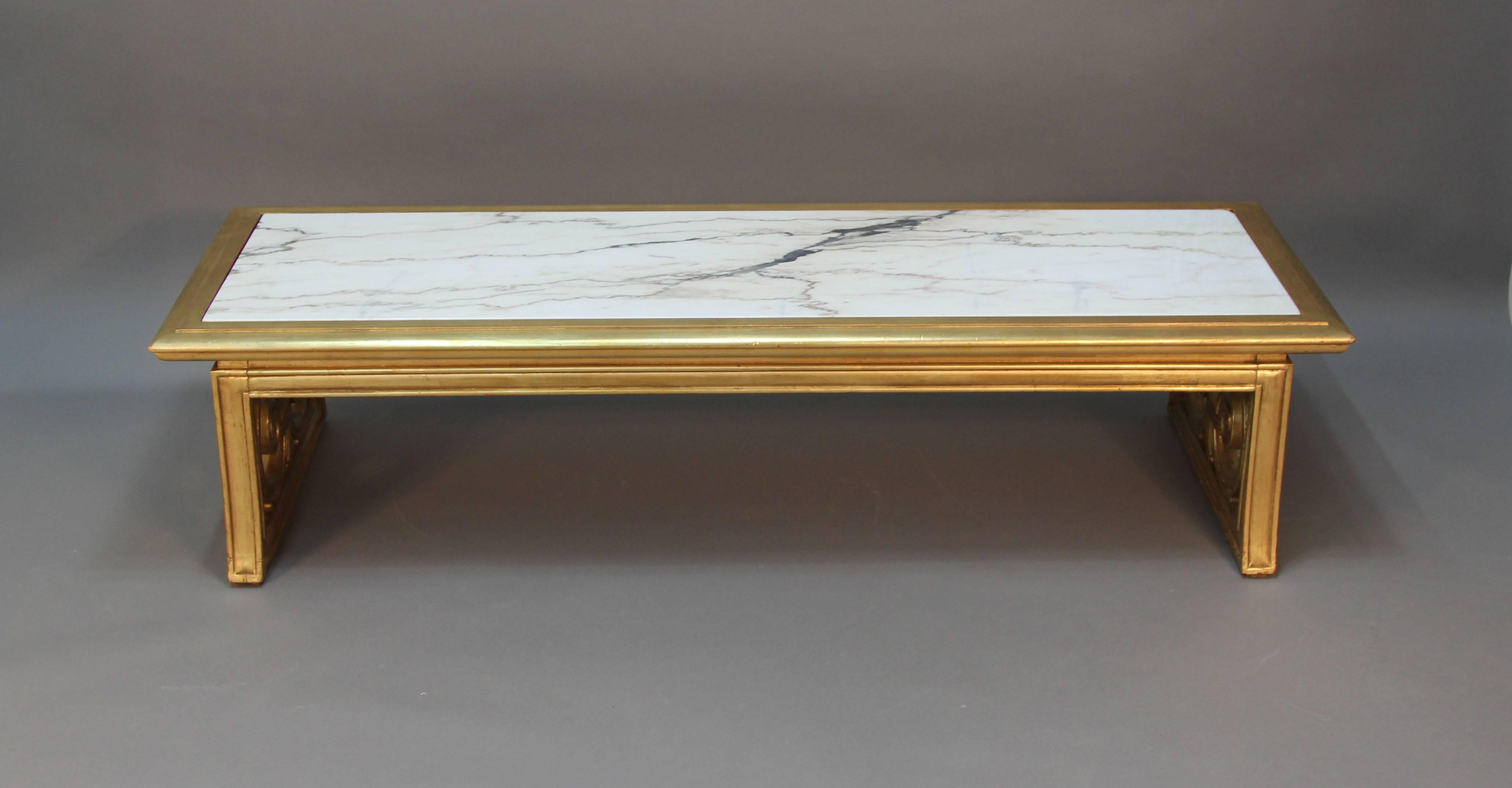 Beautiful newly gold giltwood frame coffee table with Carrara marble inset top. Scroll work detailed sides, neoclassical style.