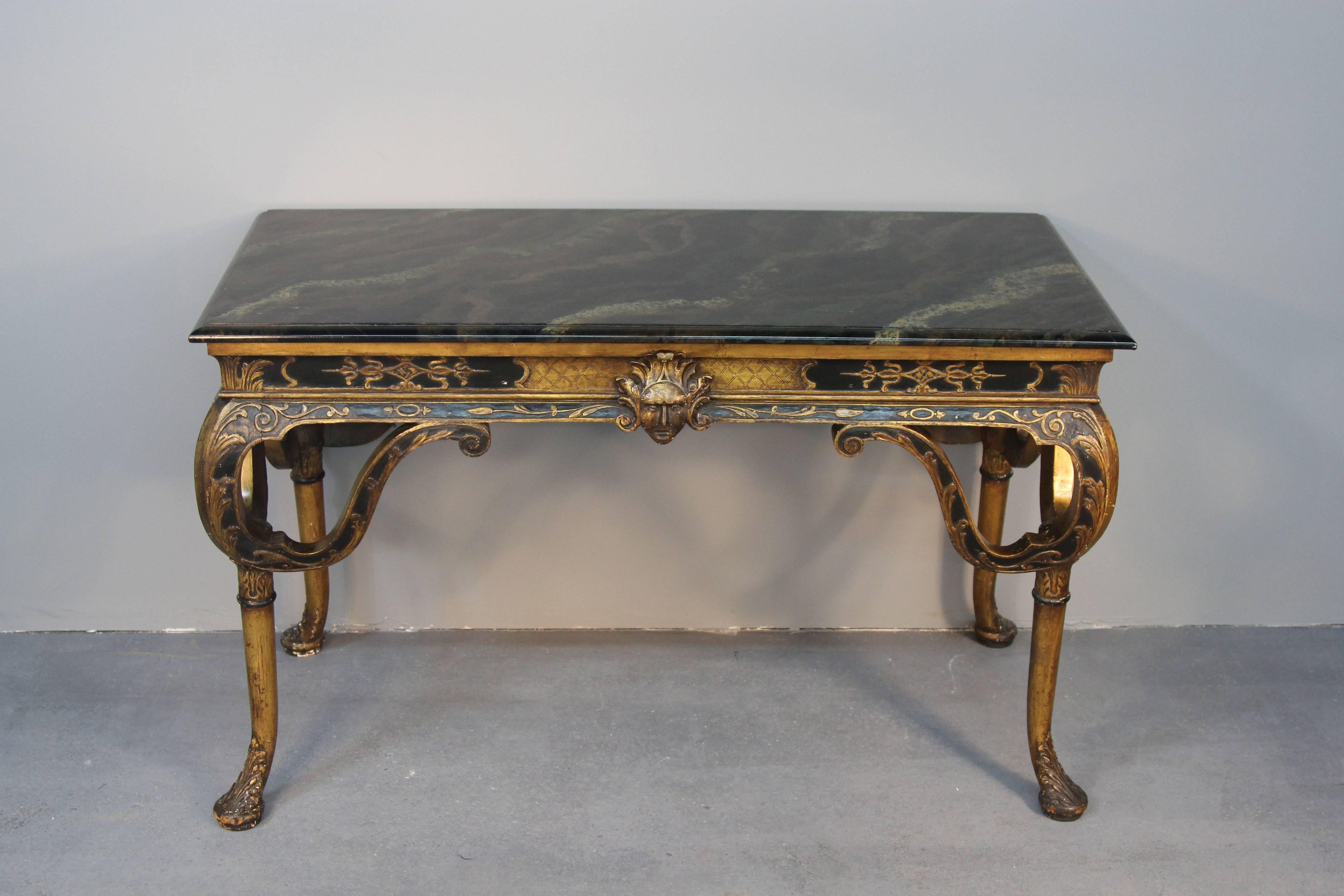 Beautiful pair of Italian gilt wood and ebonized carved console tables.  Faux marble tops.