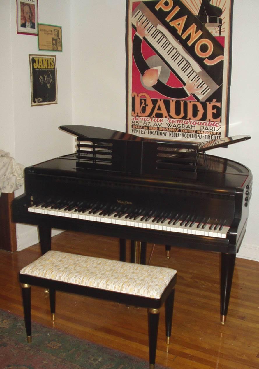 4’1” symetrical baby grand piano with matching bench.

Wood case and frame, fitted with a cast iron plate, birch ply pinblock and steel tuning pins with steel and copper wound strings. Action has a steel frame with maple parts and wool felt