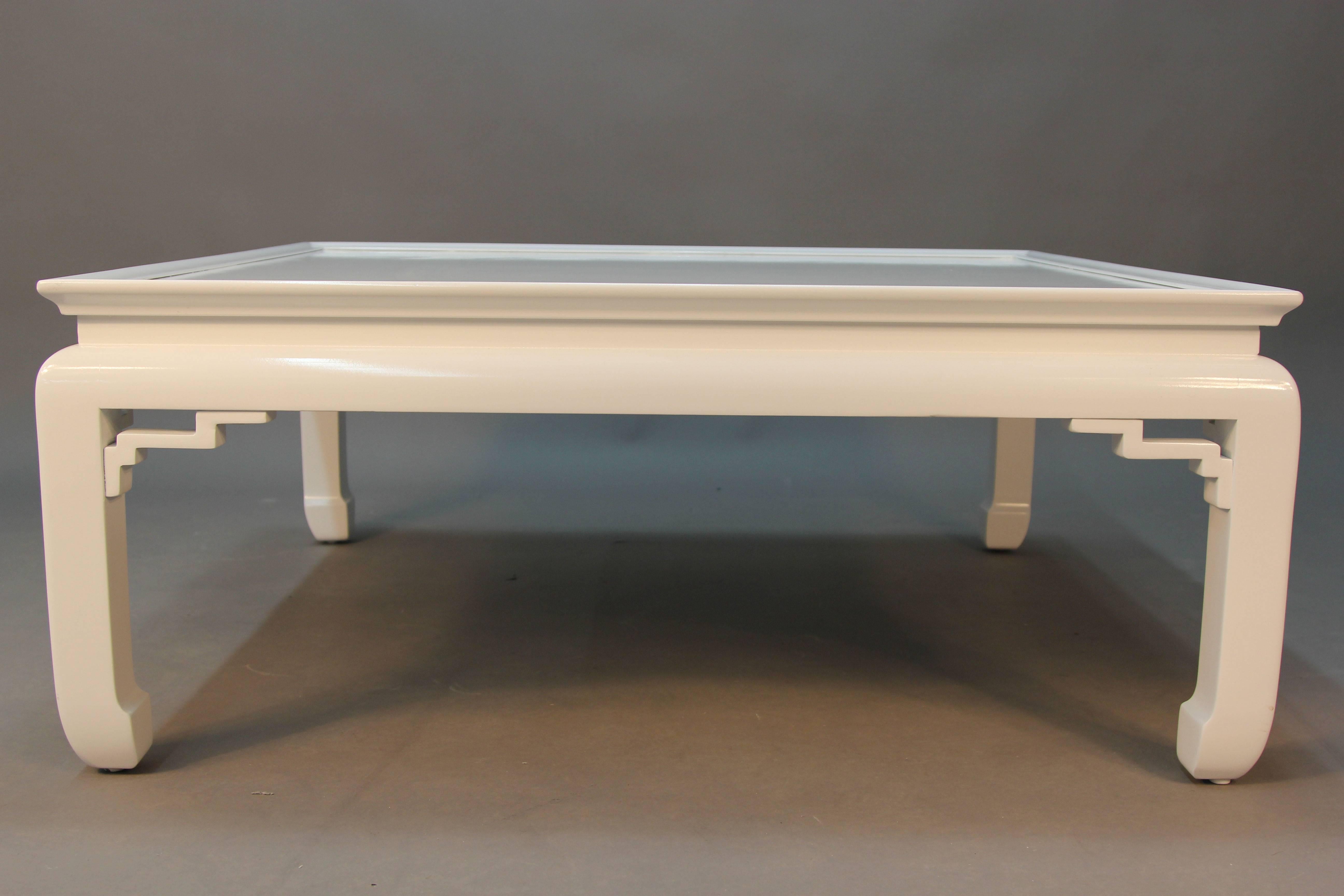 A super chic white lacquered coffee table with Asian detailed legs and design.