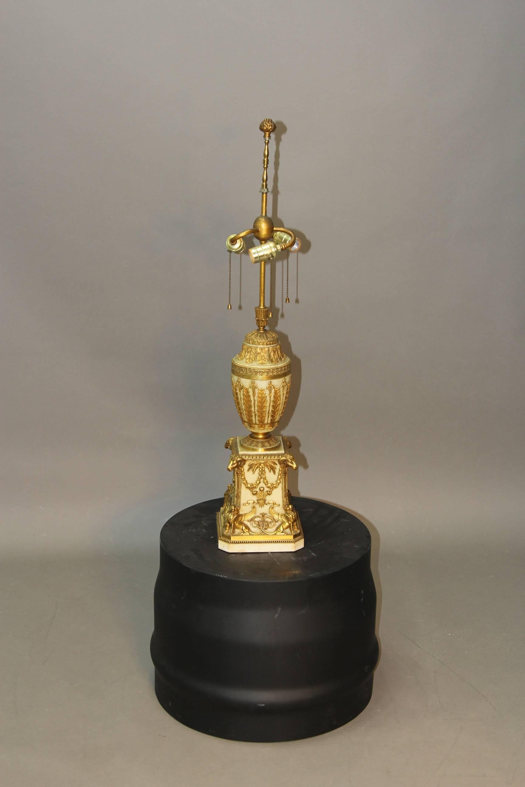 A circa 1900 museum quality ormolu gold gilt bronze lamp with rams head figural applications. In all original condition with original pine cone finial in tact.