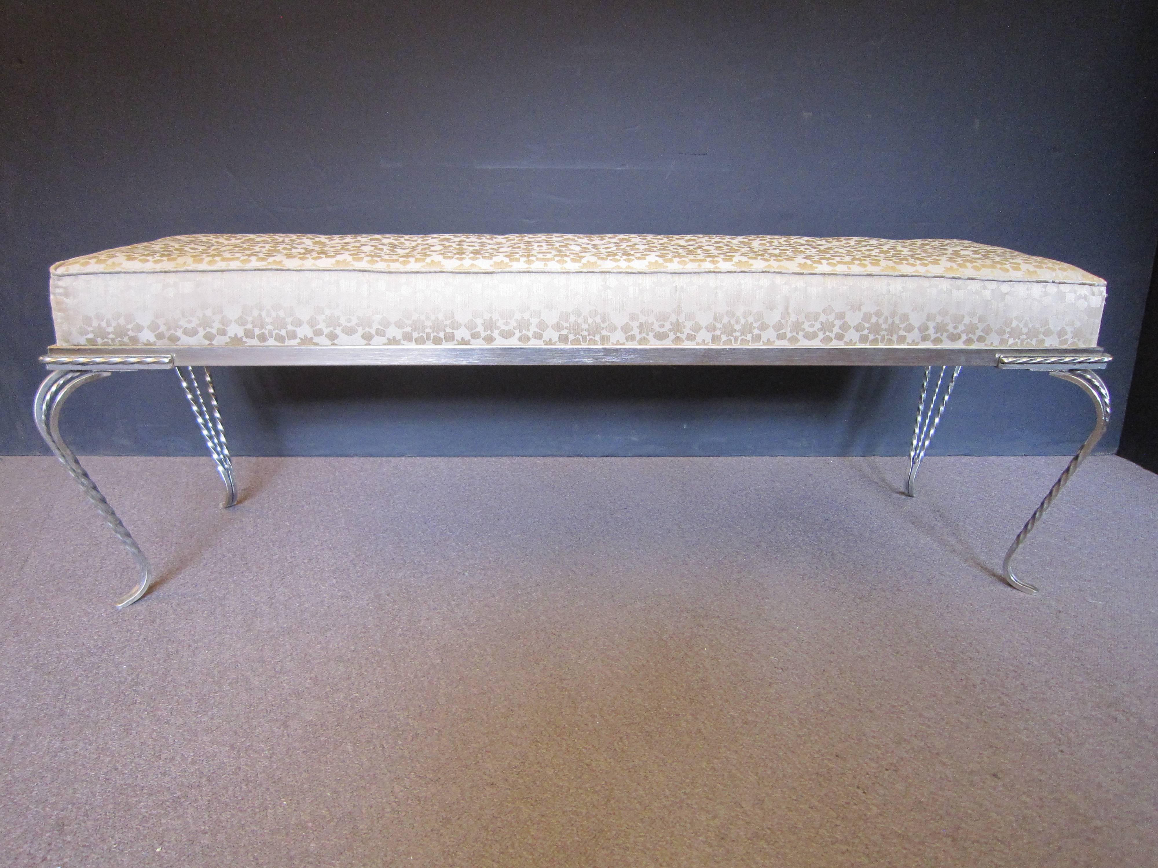 French Modernist hand hammered iron bench with four scroll legs displaying rope twist and flat stock design on the fer forge
 The tufted seat in champagne colored silky fabric features small gold hued geometric patterns overall. 
Can be used at the