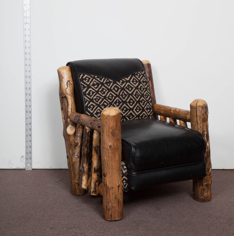 An adorable and rustic, natural wood child's arm chair, hand made in Montana, near Yellowstone. Upholstered in leather and chenille fabric, this child's throne is the perfect fit for your precious little king or queen. 
signed D.L Bingham and dated