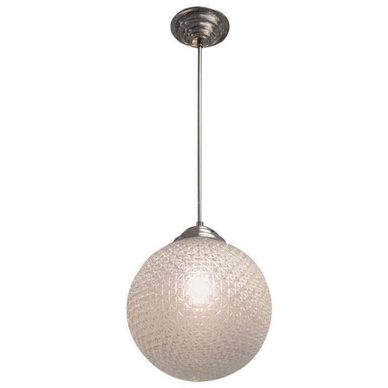 A modernist sphere of molded art glass eleven inches in diameter with diamond patterning gives the impression of finely cut crystal. Dropped from the ceiling on a single stem, from a simple concentrically round canopy; this chandelier is reminiscent