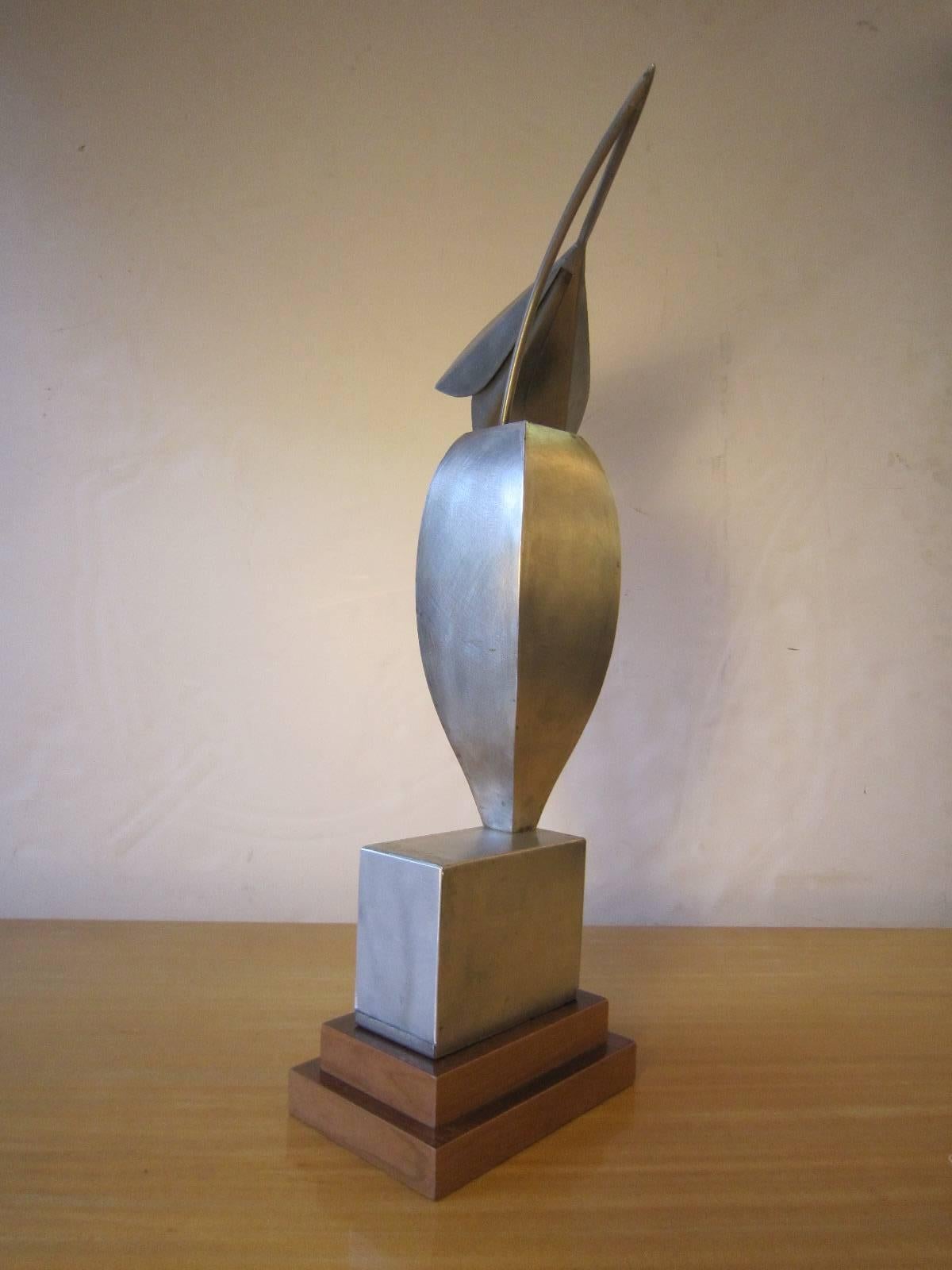 Unusual Modernist statue of a highly stylized bird on stepped wood base.
Using elements from nature, this work of art portrays Dual semblance as an animal and as a vessel or flower vase. The artist exudes in his sculpture simplicity of form. His