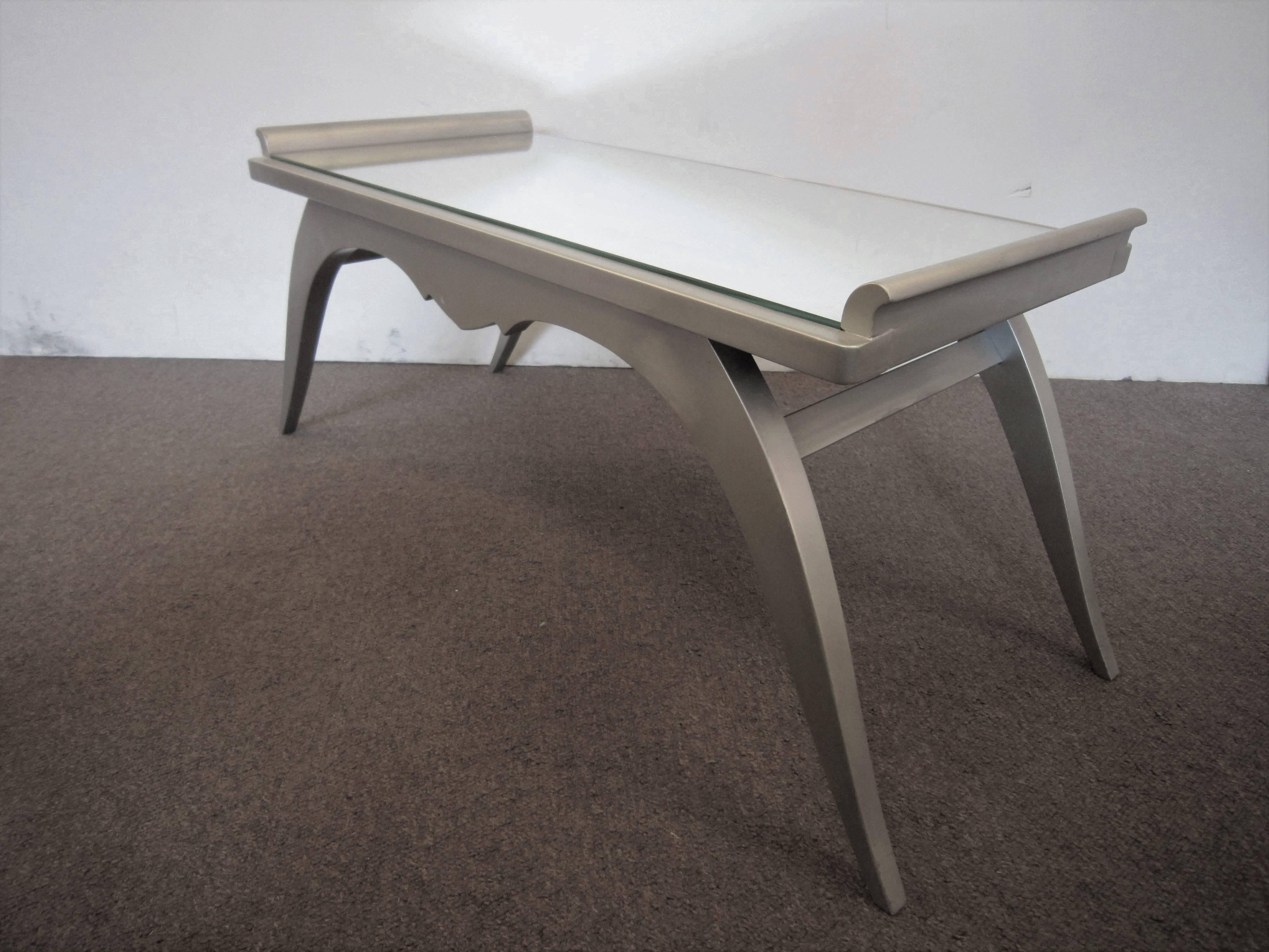Un elegante tavolo da cocktail francese Art Deco in foglia d'argento su legno con piano a specchio.
Combinando sia la forma che la decorazione, l'artista è riuscito a creare un tavolo di ispirazione classica, in stile revival egiziano, con gambe