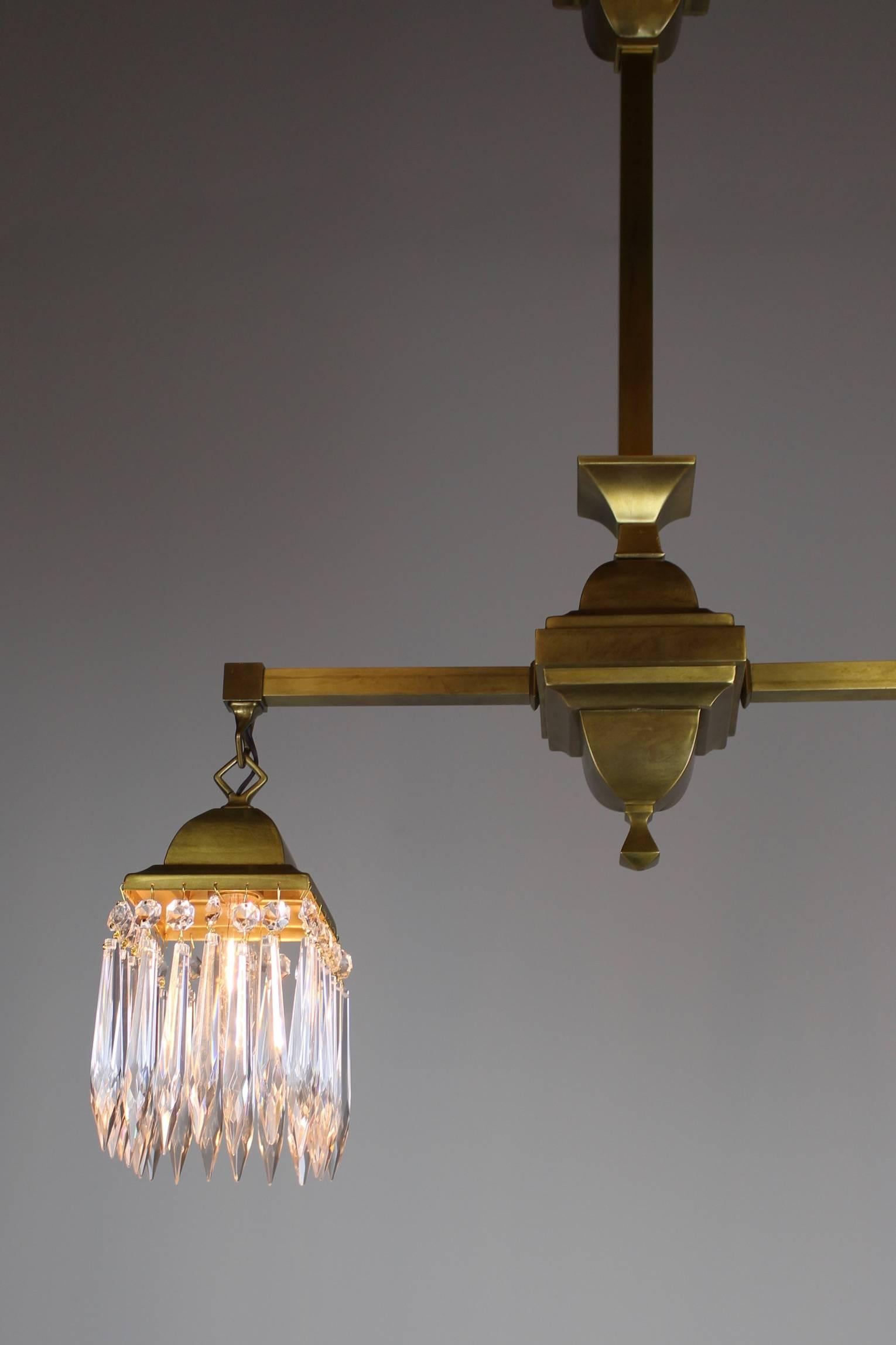 An original mission-link fixture with crystal shades, a hard to find original combination, circa 1910. This two-arm fixture, has been restored to its original satin brass finish. A very pleasant design and striking choice for any