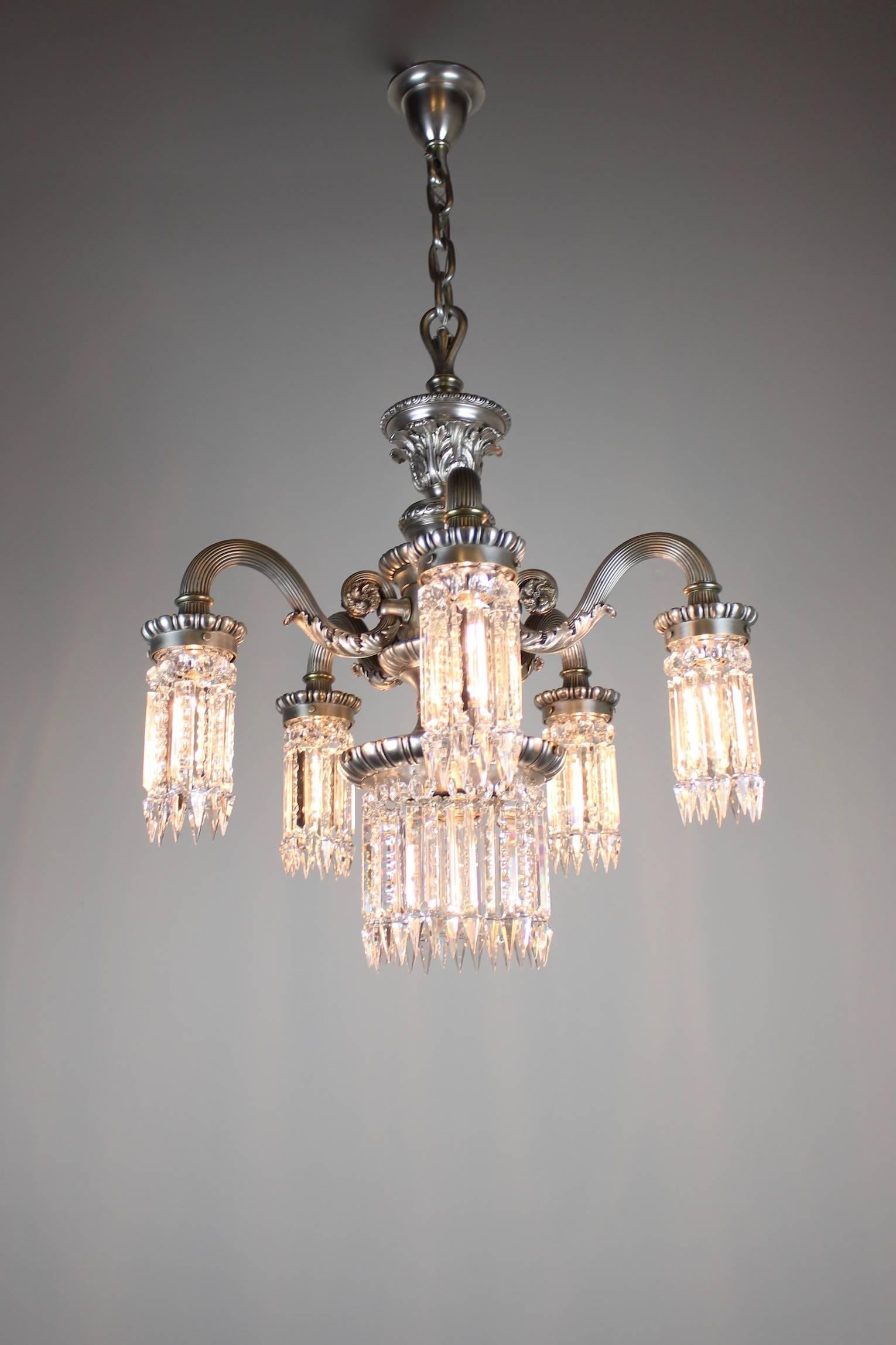 This is a hearty and gorgeous neoclassical style chandelier, with five arms and a wide centre light, circa 1910. This fixture boasts the best of neoclassical design motifs with reeded arms and acanthus leaf castings. An excellent choice for a hearty