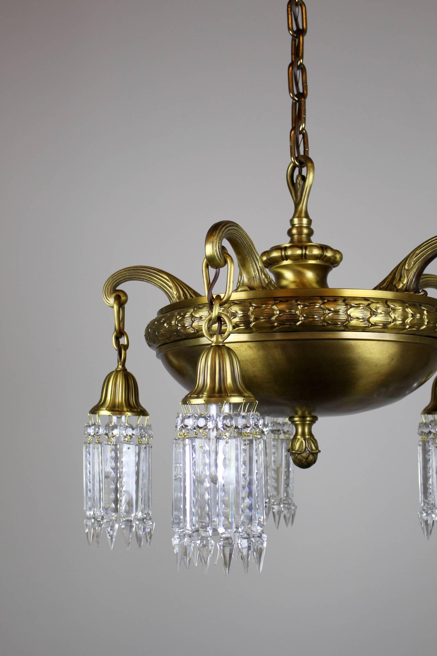 A killer crystal chandelier in the Beaux Arts style, circa 1910. Five arms, fitted with notched crystal. This bank style light has hearty brass body with beautiful castings around the rim. Rewired and restored, ready to hang.  Measurements: 49"